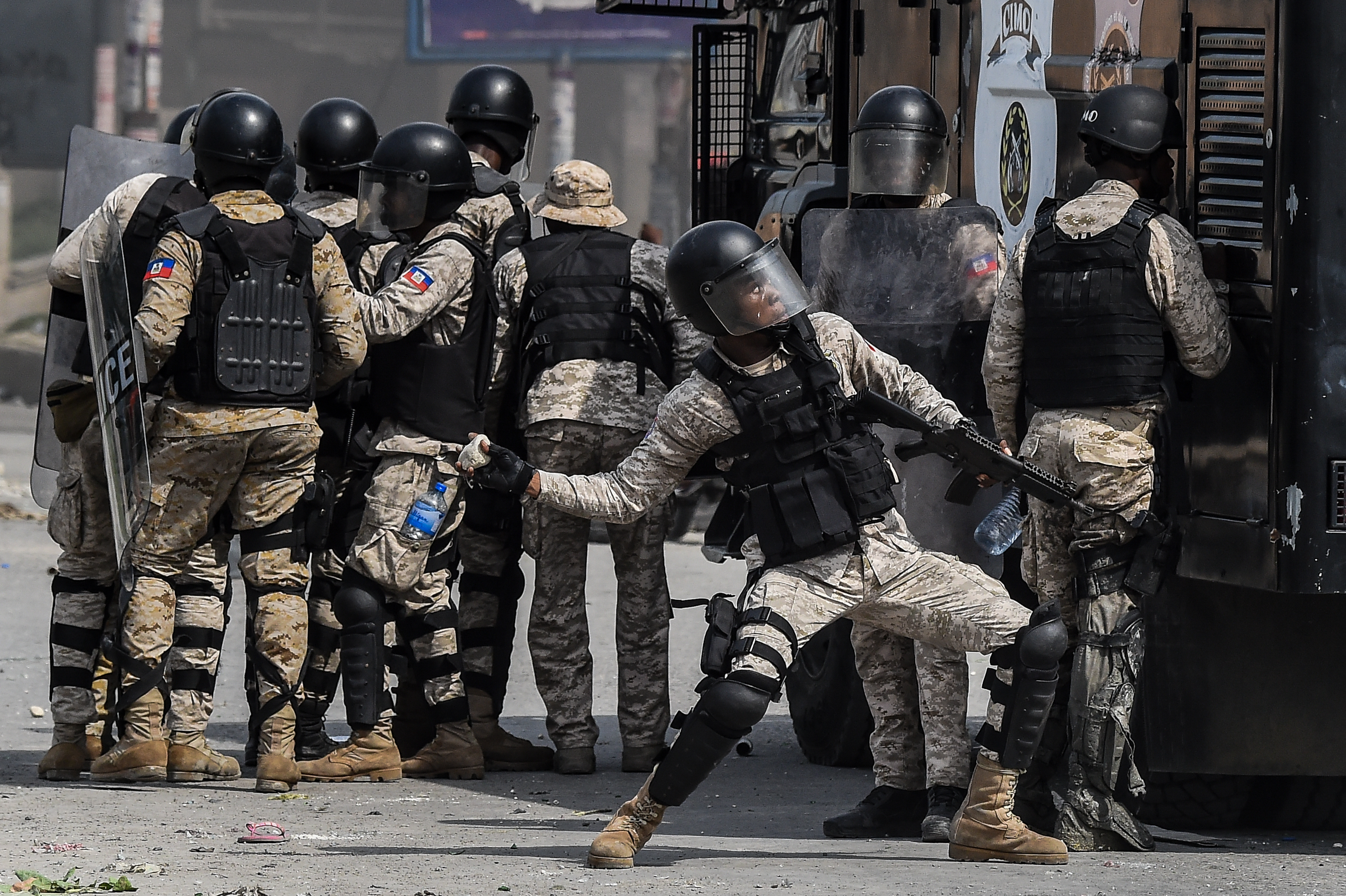 A police officer throws a stone during a protest outside United Nation's main base, against President Jovenel Moise on October 4, 2019 in Port-au-Prince, Haiti.