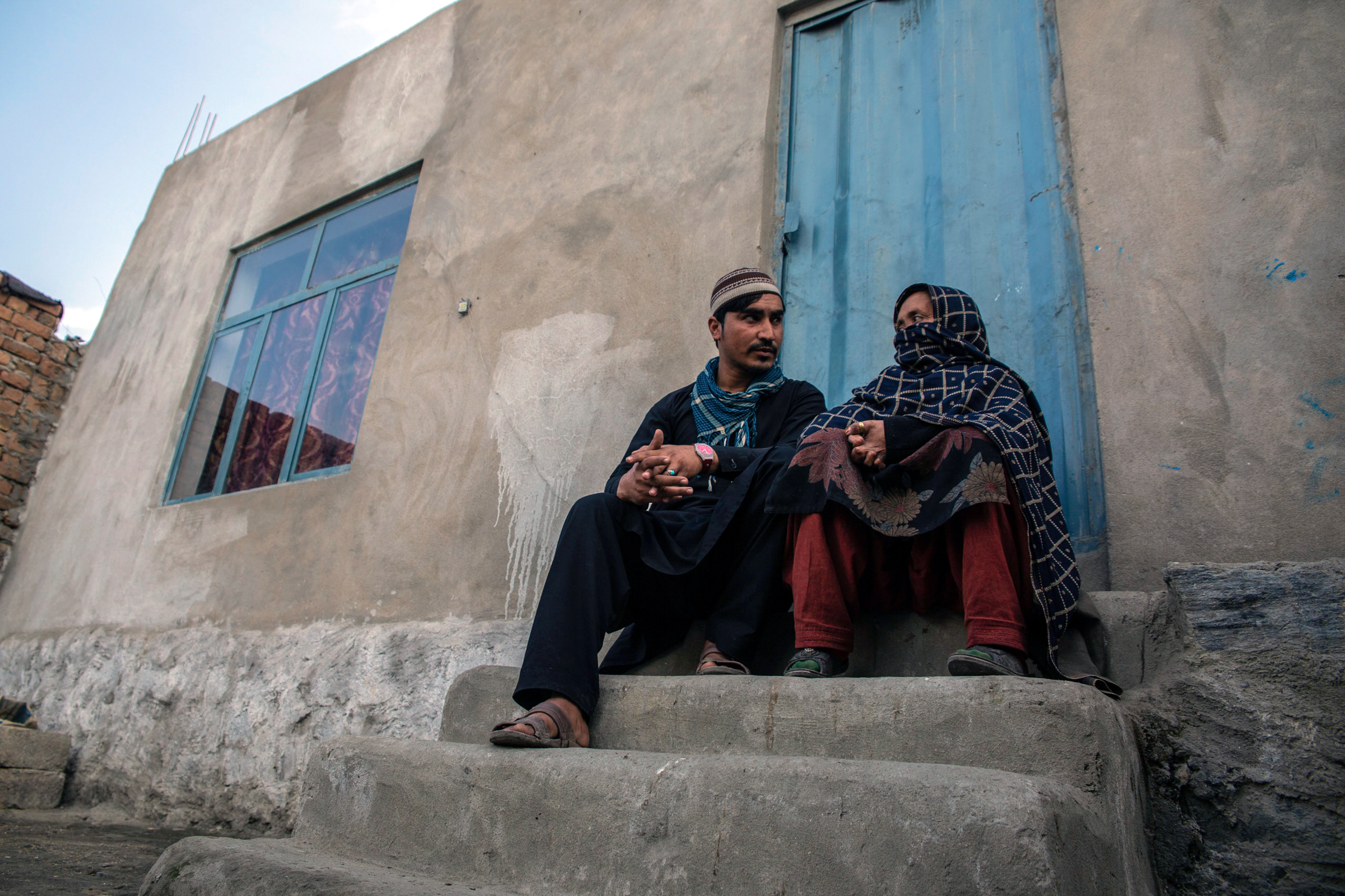 Photo of people who have returned to Afghanistan near Jalalabad sitting outside of their home.