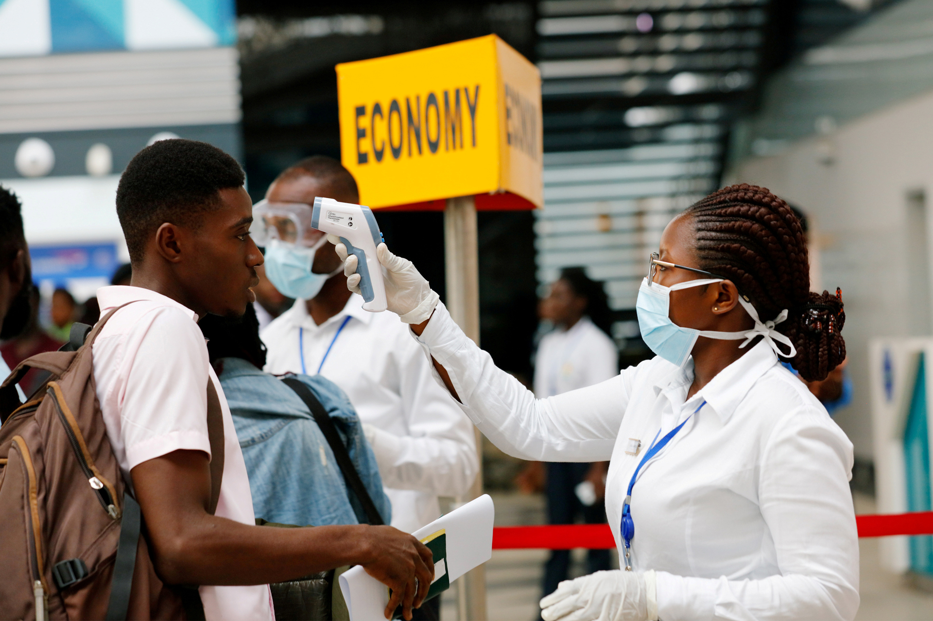 A health worker checks the temperature of a traveller in coronavirus screening at Kotoka International Airport, Accra, Ghana.
