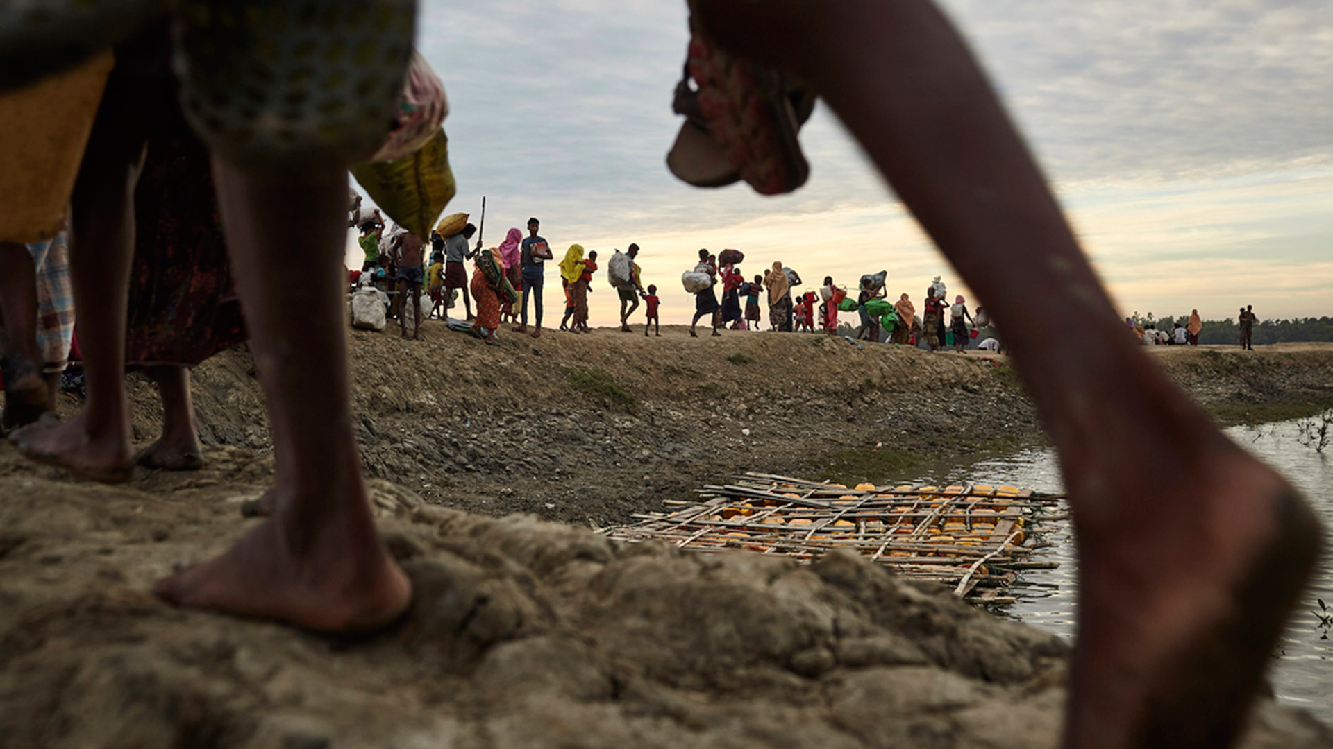 Rohingya refugees walk on an embankment of the Naf River, which separates Myanmar and Bangladesh, in November 2017.