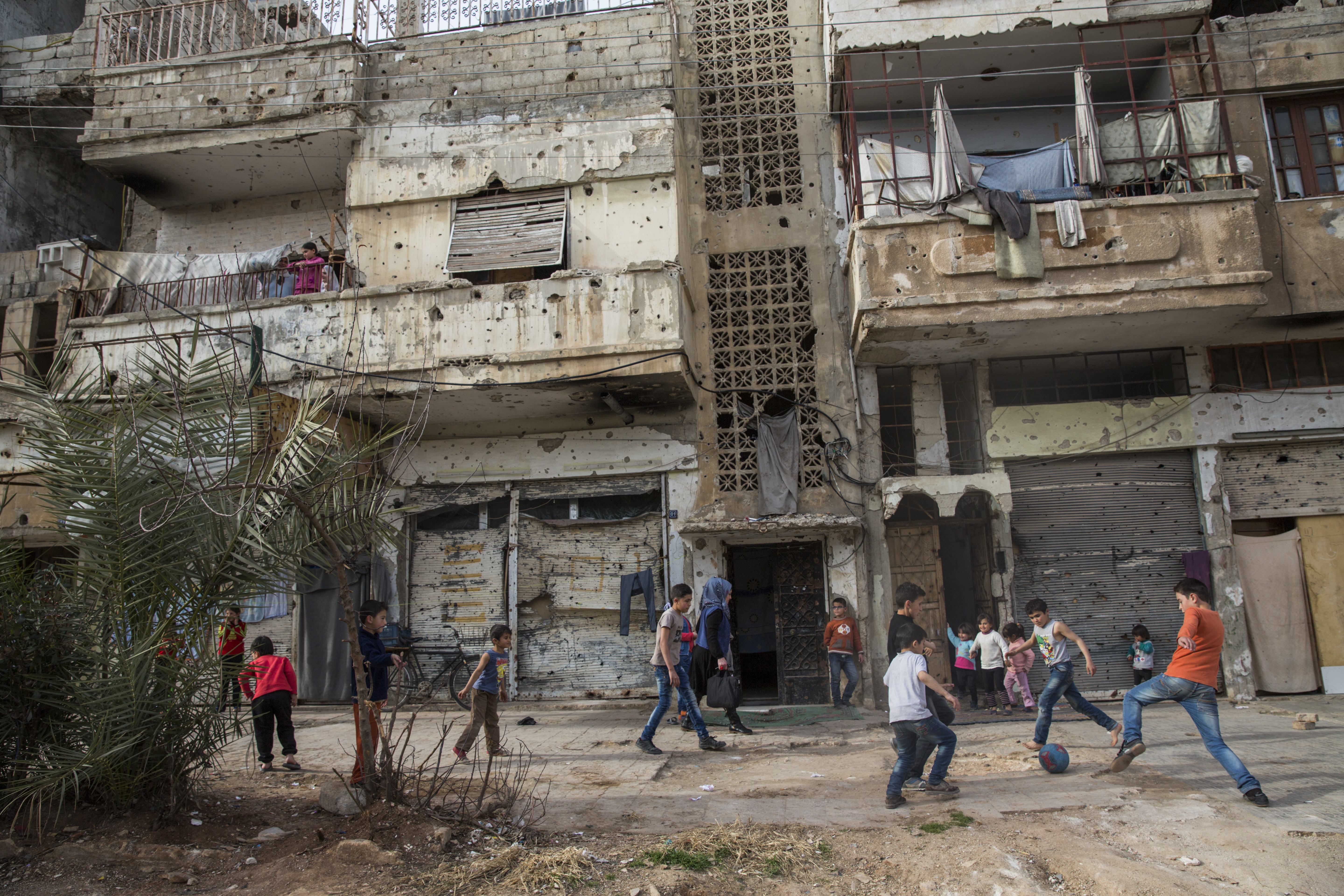Children play football on a street in Baba Amr, Homs, Syria
