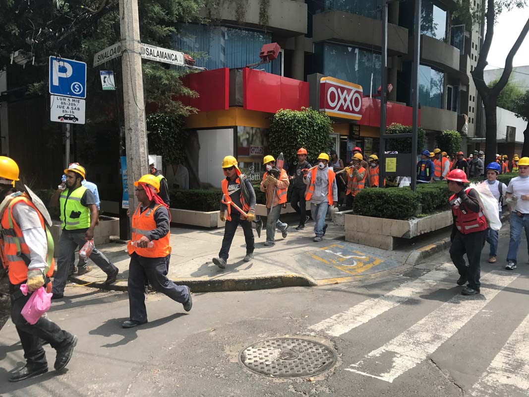 Volunteers march down a street in the Roma neighbourhood heading to a collapsed building after the earthquake in Mexico City.