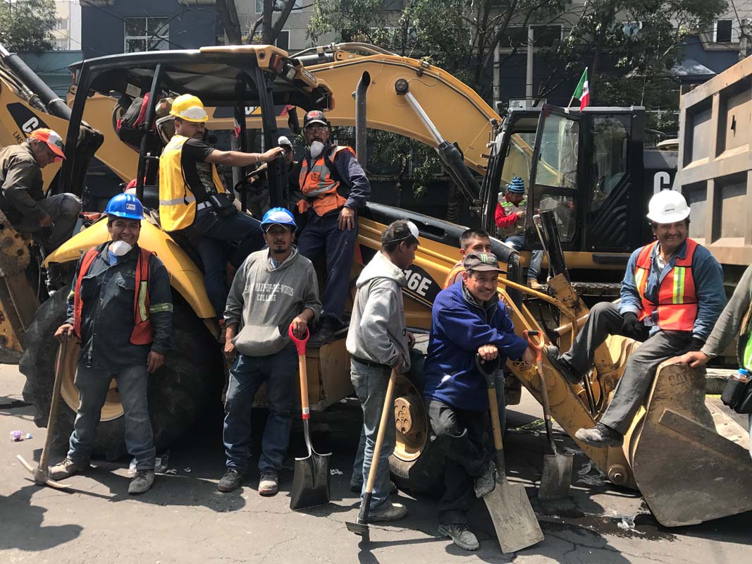 A crew of construction workers waits for orders outside one of the buildings that collapsed in Mexico City's Roma neighbourhood.