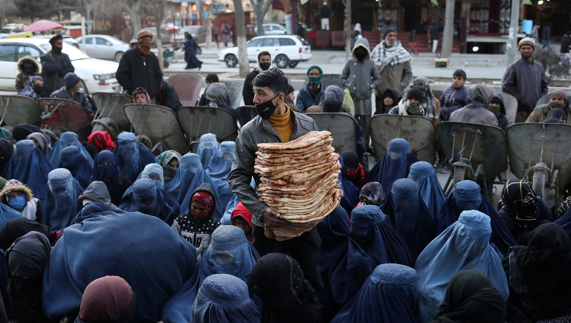 A man distributes bread at a market in Kabul, Afghanistan, on 31 January 2022. Drought and a crumbling economy are driving rising hunger.