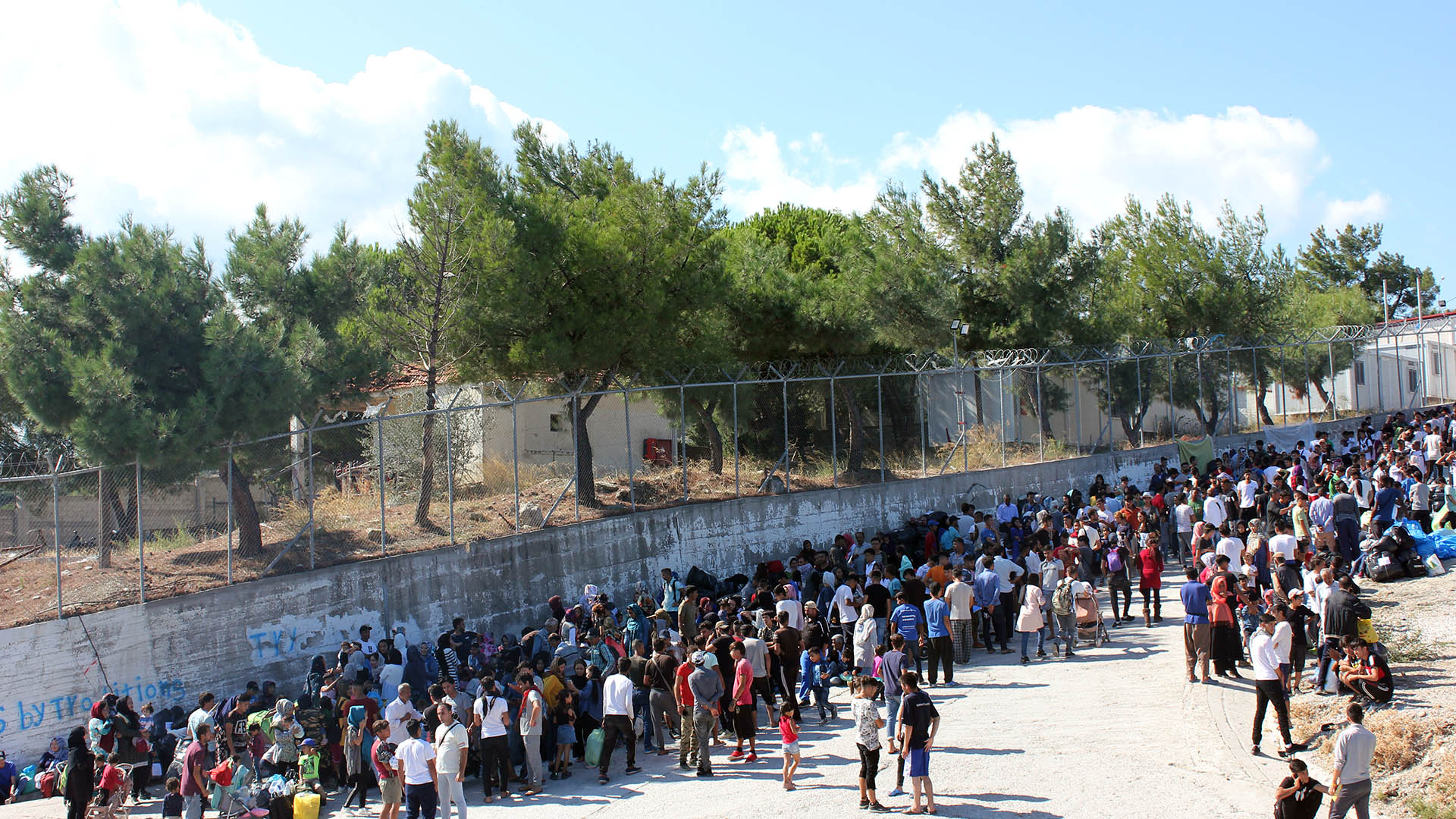 Asylum seekers wait outside the Moria processing centre on the Greek island of Lesvos.