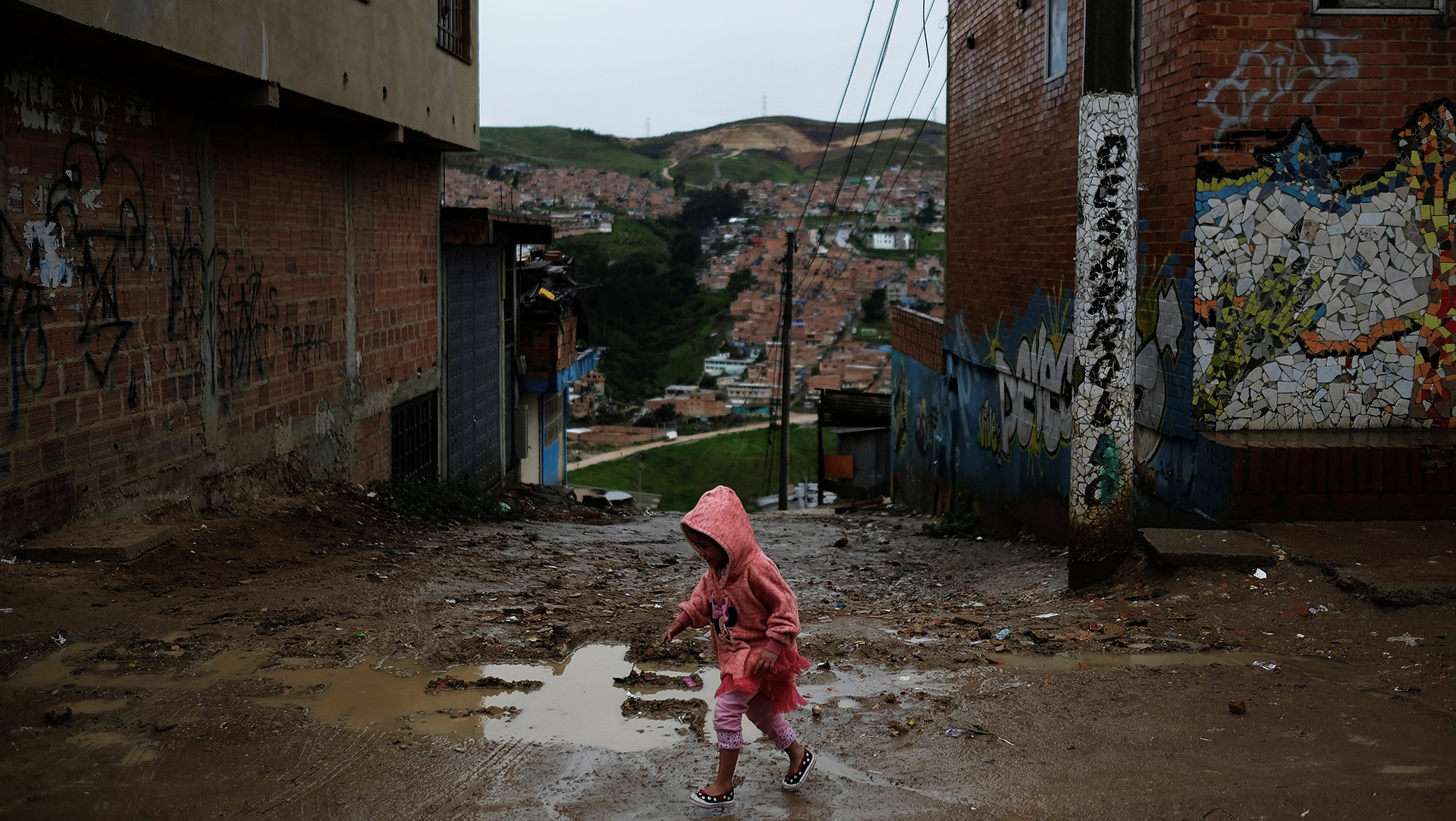 A child walks on the street of a slum in Soacha, on the outskirts of Bogotá, Colombia