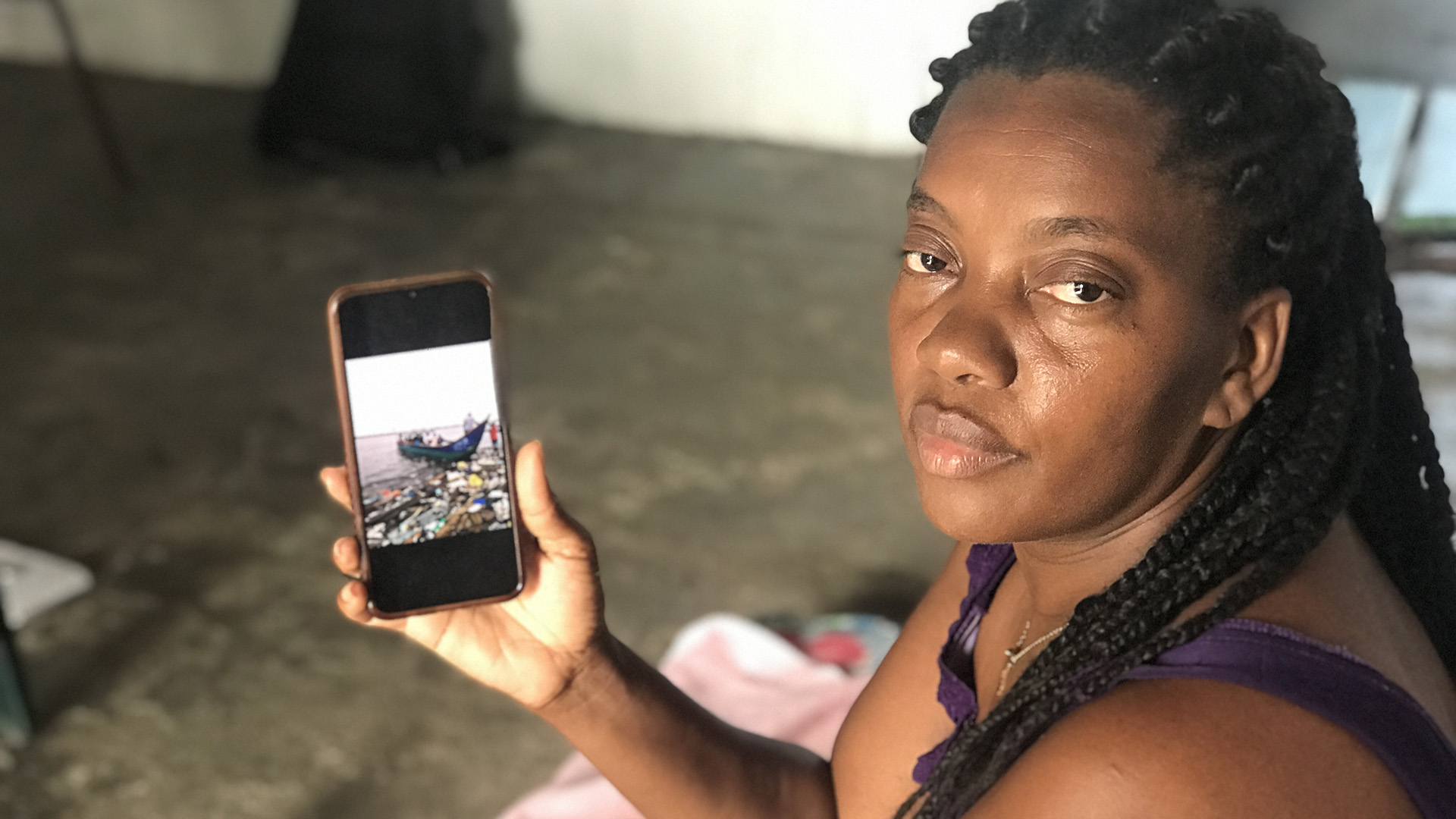 Nury Cabezas shows cell phone photos of displaced people