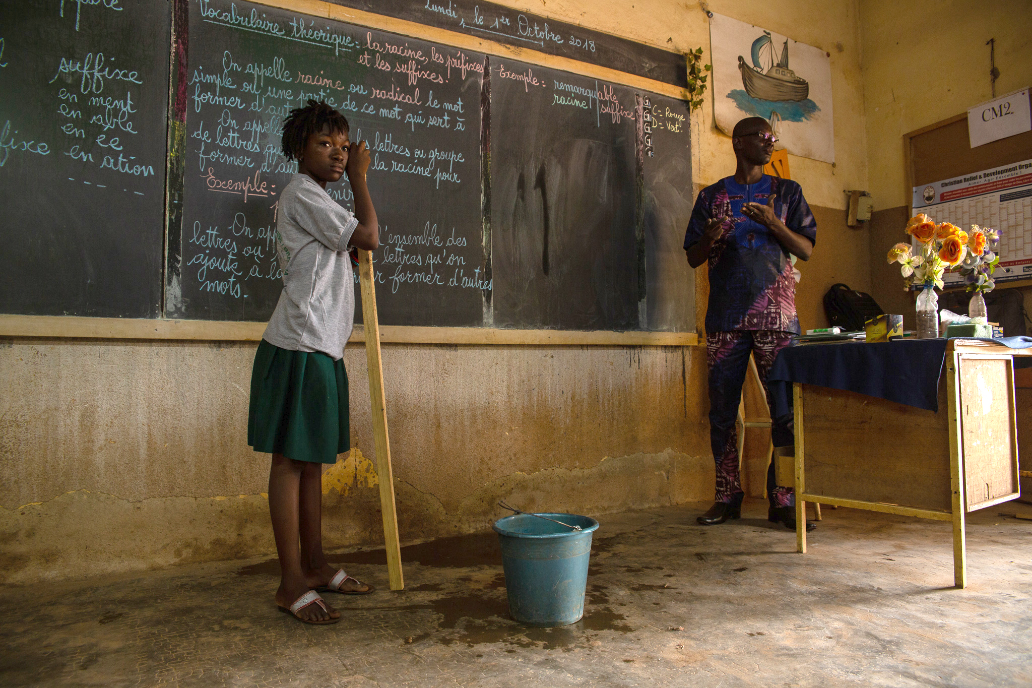 A teacher and a student in front of a chalk board