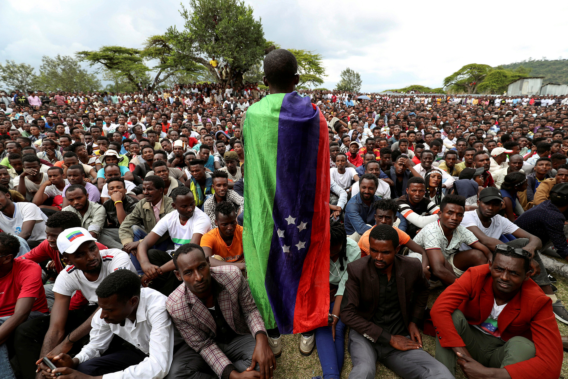 A Sidama youth leader carrying a flag addresses people as they gather for a meeting to declare their own region in Hawassa, Ethiopia.
