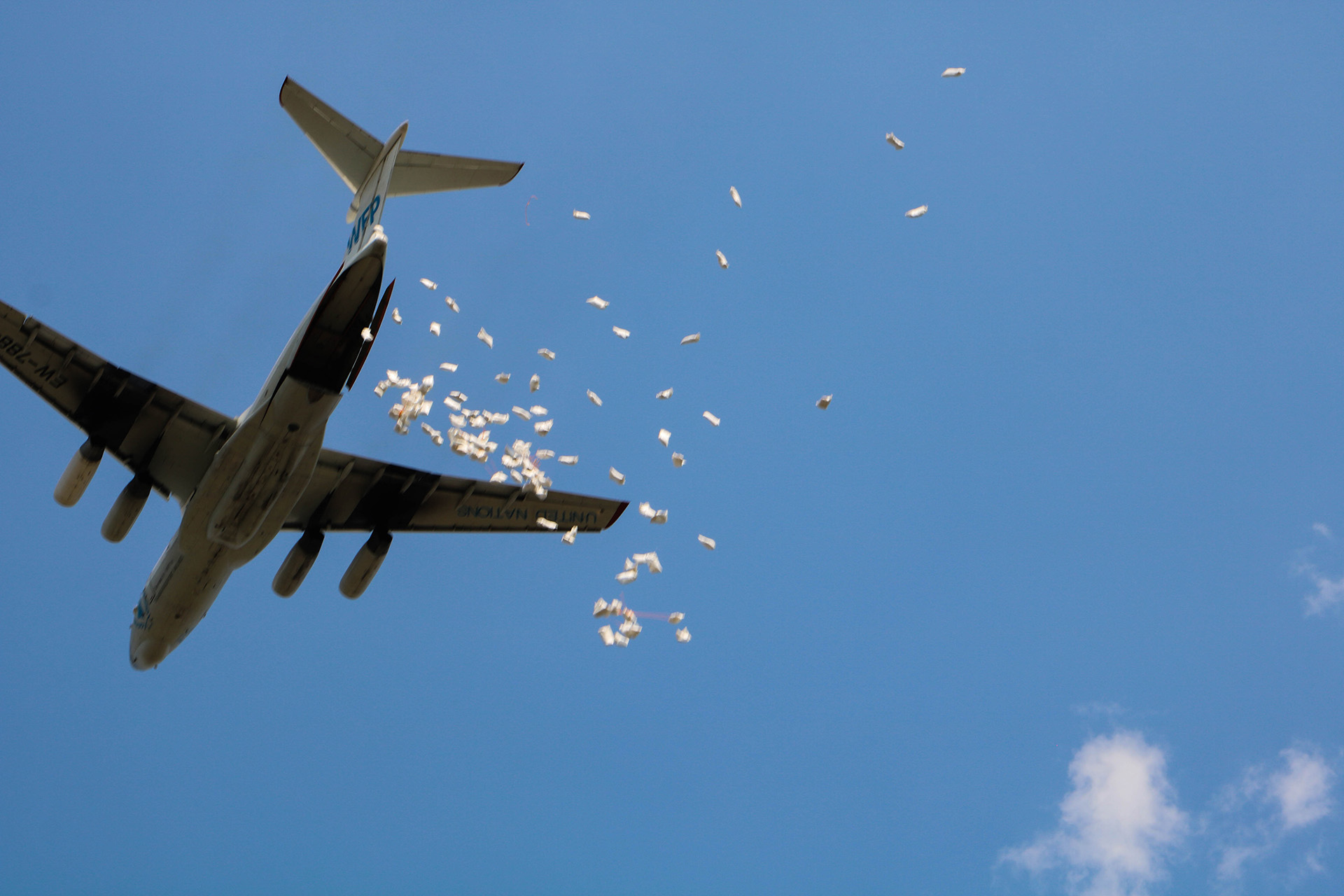 The view of the underside of a World Food Programme plane, as it drops food over Pibor town.