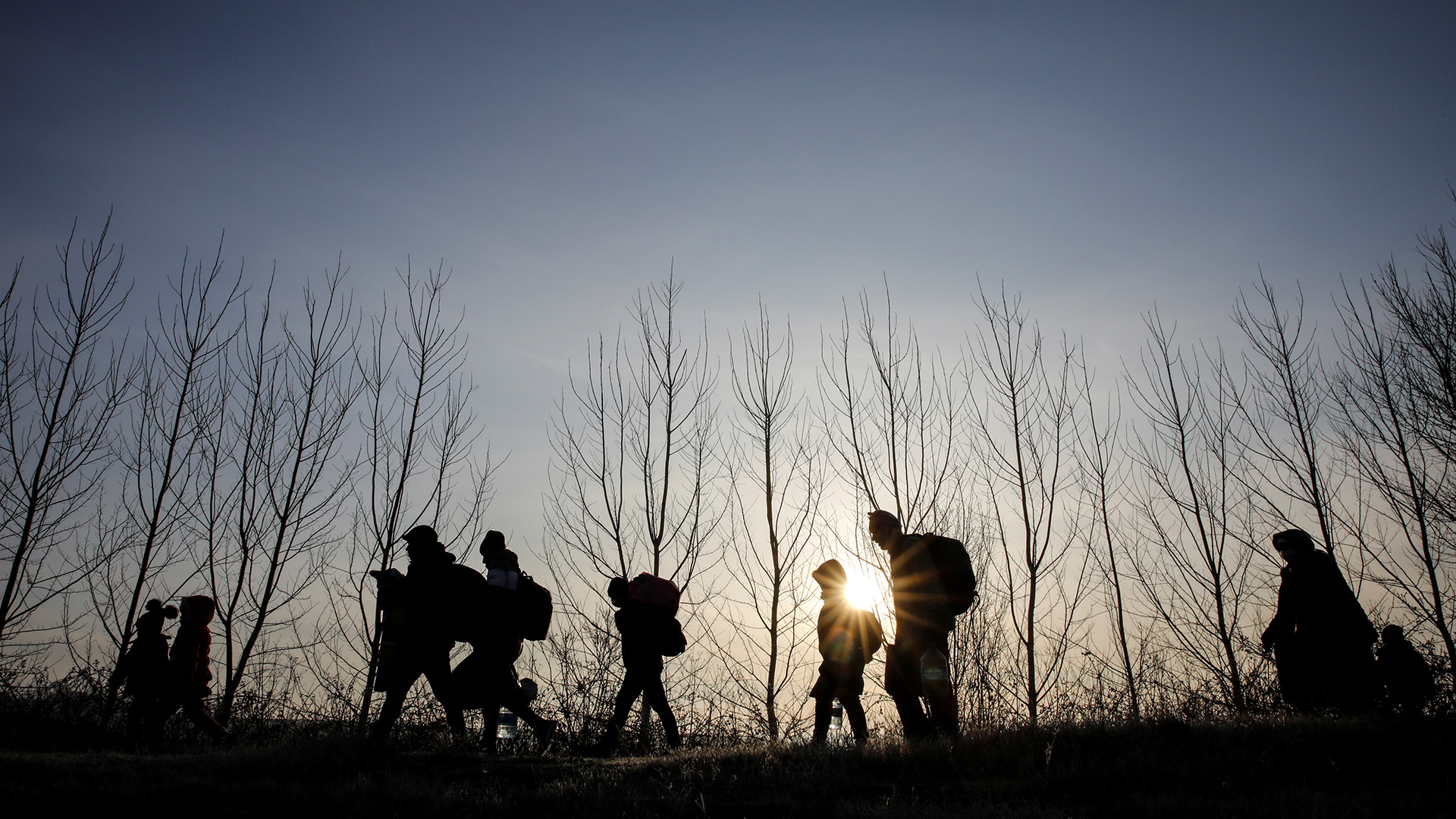 Migrants walk along the Evros River to reach Greece