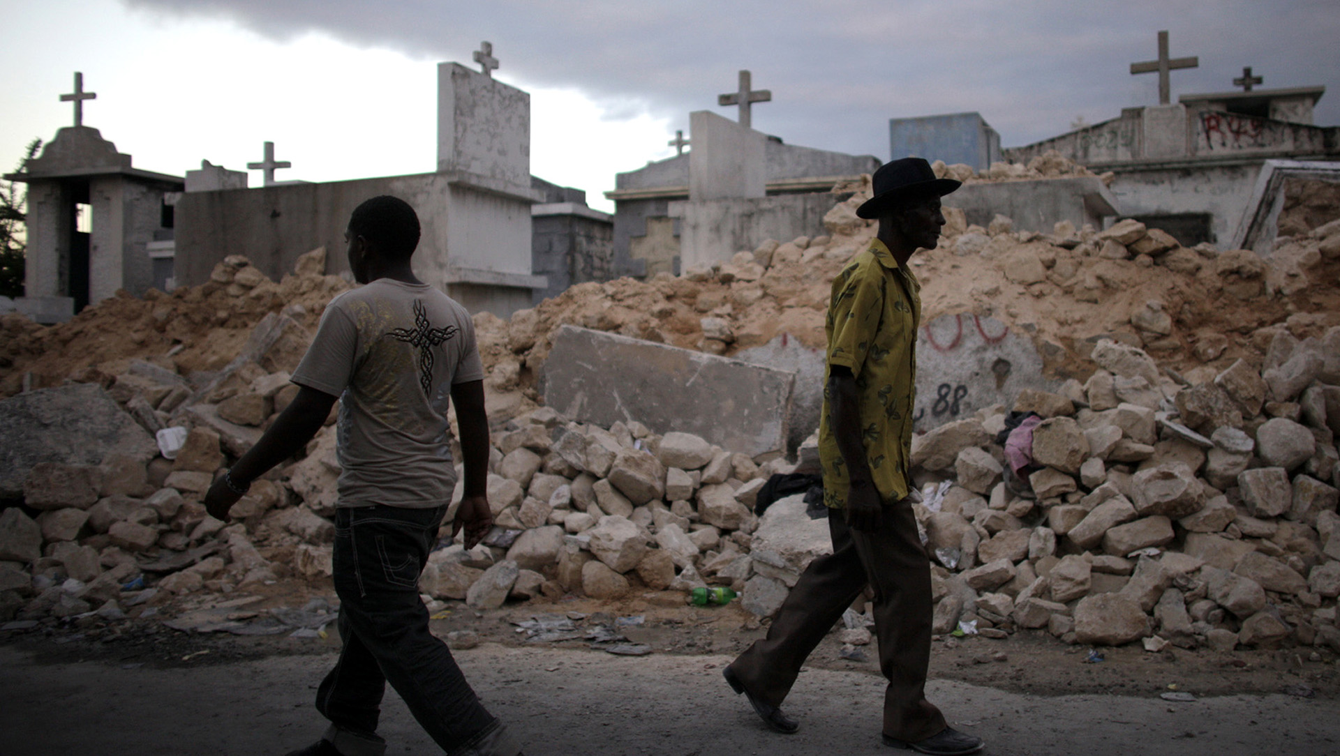 People walk in front of a destroyed cemetery in Port-au-Prince after the January 2010 earthquake that flattened much of the capital and claimed between 100,000 and 300,000 lives.