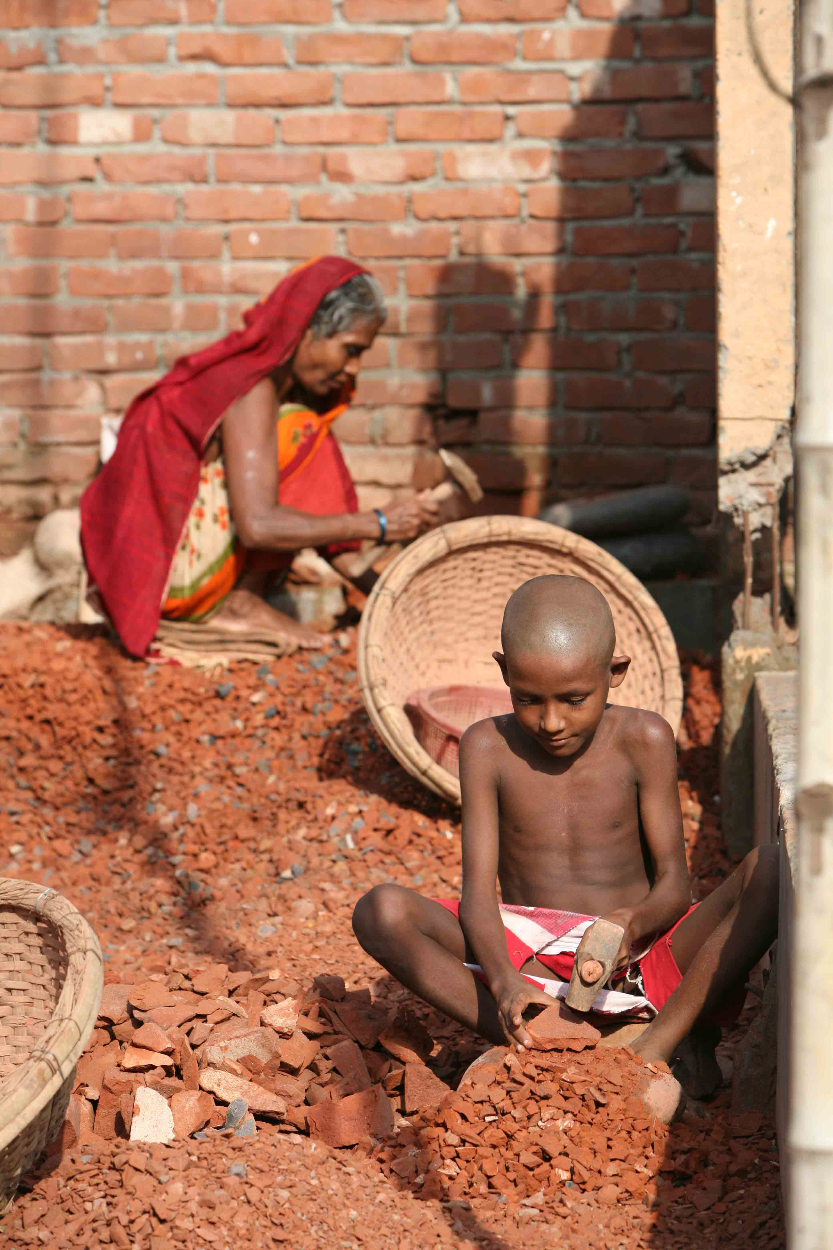 A young boy engages in traditional brick-making in Dhaka, Bangladesh, July 2007. More than 400,000 children in Dhaka work from dawn until dusk each day to help support their families.