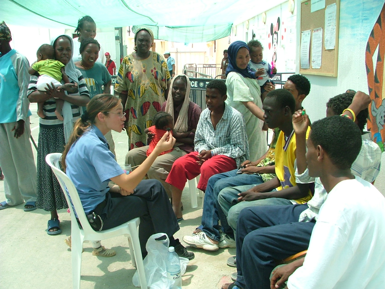 An Israeli guard explains matters to new arrivals in the refugee camp.