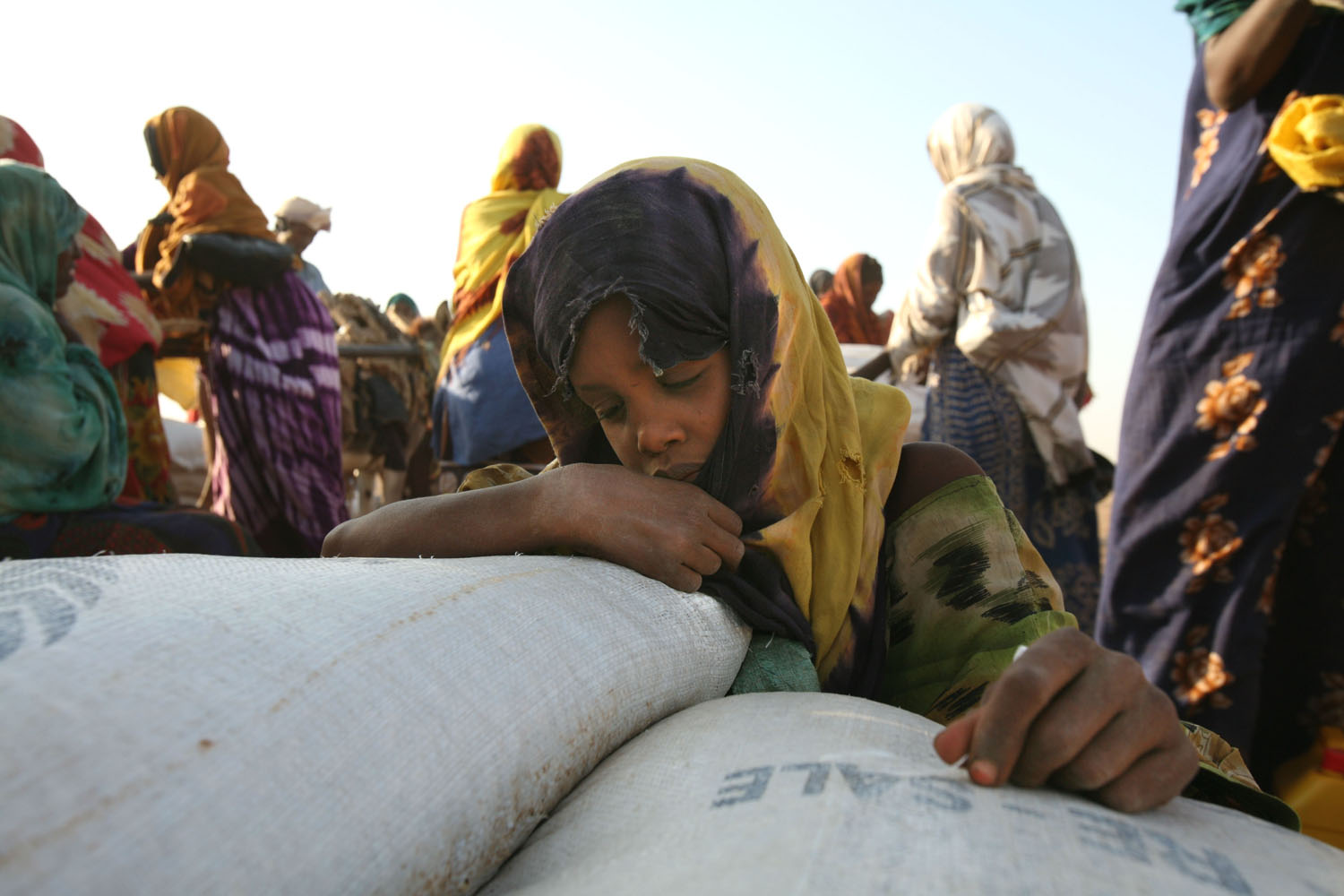 A girl relaxes on the sacks of maize at the food distribution in Jowhar, Somalia, September 2007. Up to 1.5 million of Somalia's estimated seven million people need food aid. Nearly 300,000 face severe food shortages in the Horn of Africa nation.