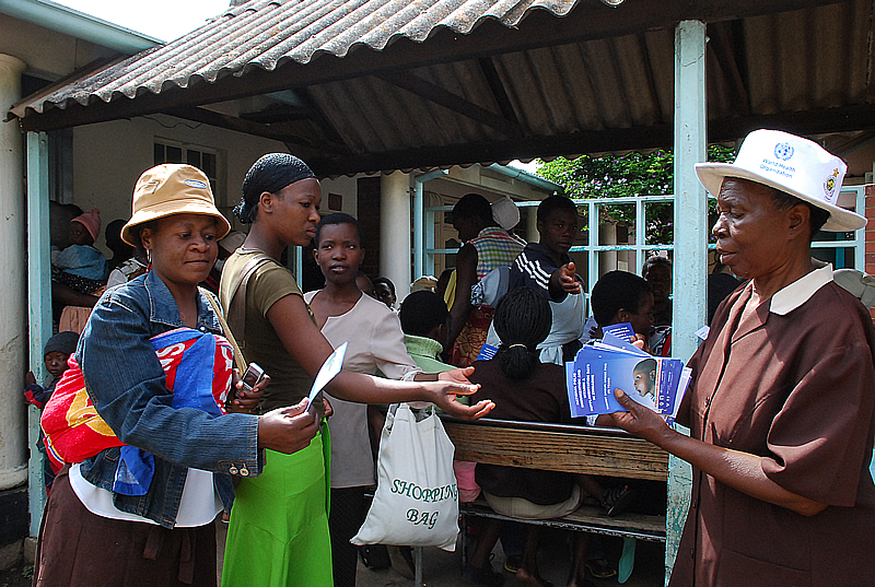 A health promotion worker from the City of Harare's Health Department distributes flyers with information on why children should be vaccinated. The Child Health Days (CHDs) are being co-ordinated by the Ministry of Health and Child Welfare in partnership