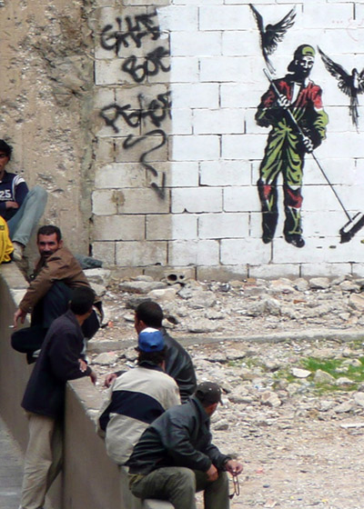 Graffiti of a Syrian street sweeper covers a Beirut wall where migrant workers, most of them Syrians, wait every day for casual labour.