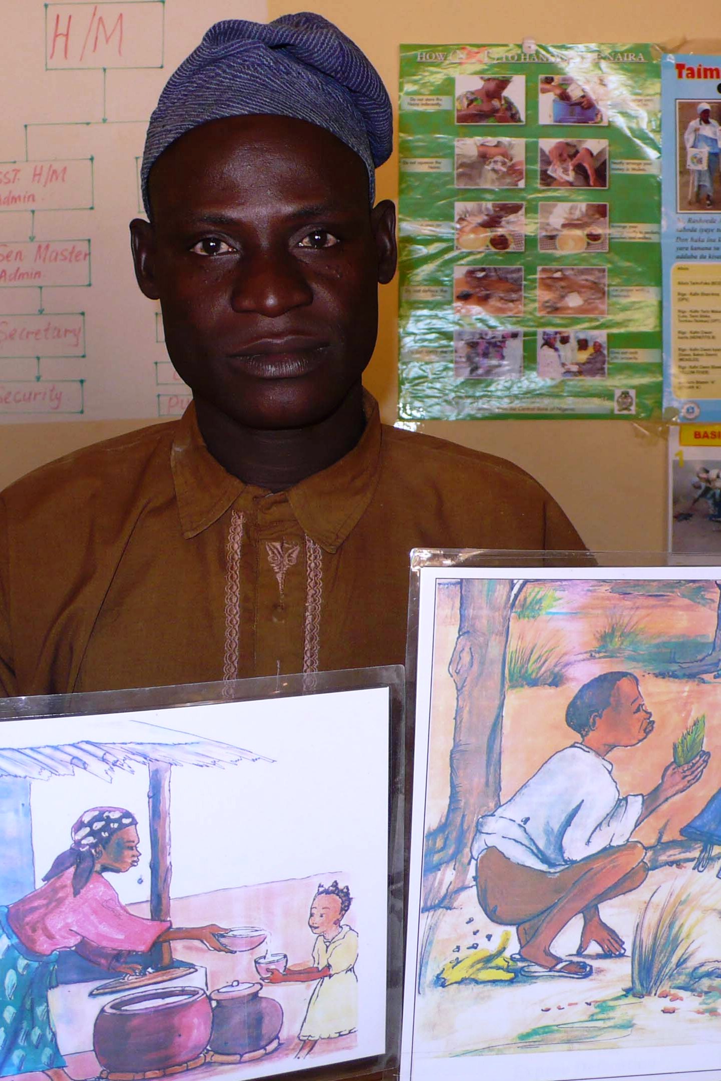 Sani Marafa, the headteacher for the Lokoto primary school shows drawings to raise awareness on the importance of using latrines.