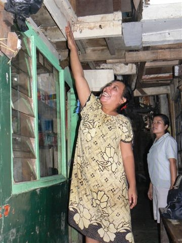Housewife Ratna Dewi shows how water reached the first floor of her house in this poor neighborhood in central Jakarta during recent floods.