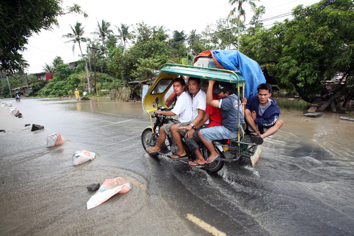 A public transport motorbike passes in a flooded road near Legazpi City, Albay Province, Bicol Region, the Philippines, March 2008. After six days of improving weather condition in Bicol, heavy rains spawned by a shallow low pressure area (LPA) again poun