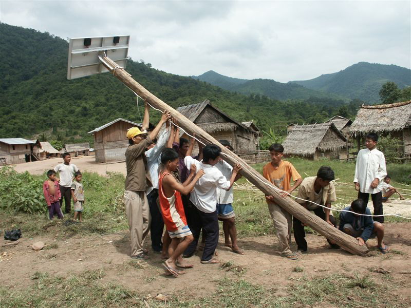 Lao villagers erect a solar panel system.