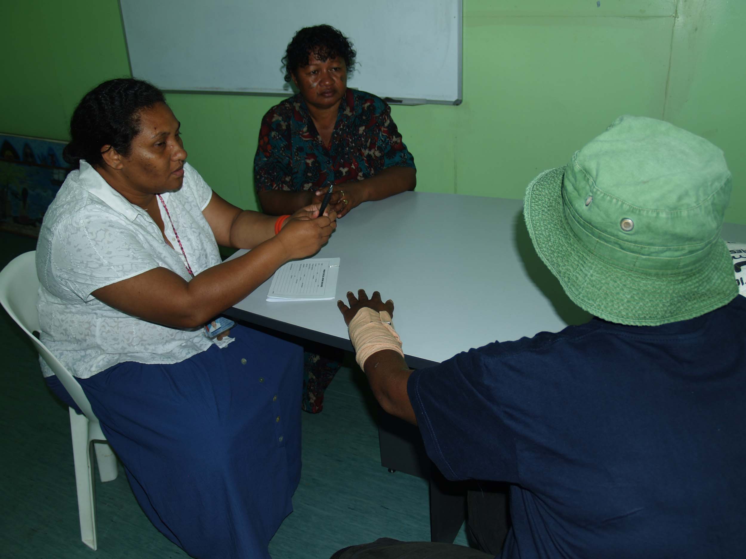 Tessie Soi, (left) who runs the Family Crisis Center at Port Moresby General Hospital and social worker Priscilla Agelava (center) counsel a woman who has been abused by her husband. Domestic violence against women and children is endemic in Papua New Gui