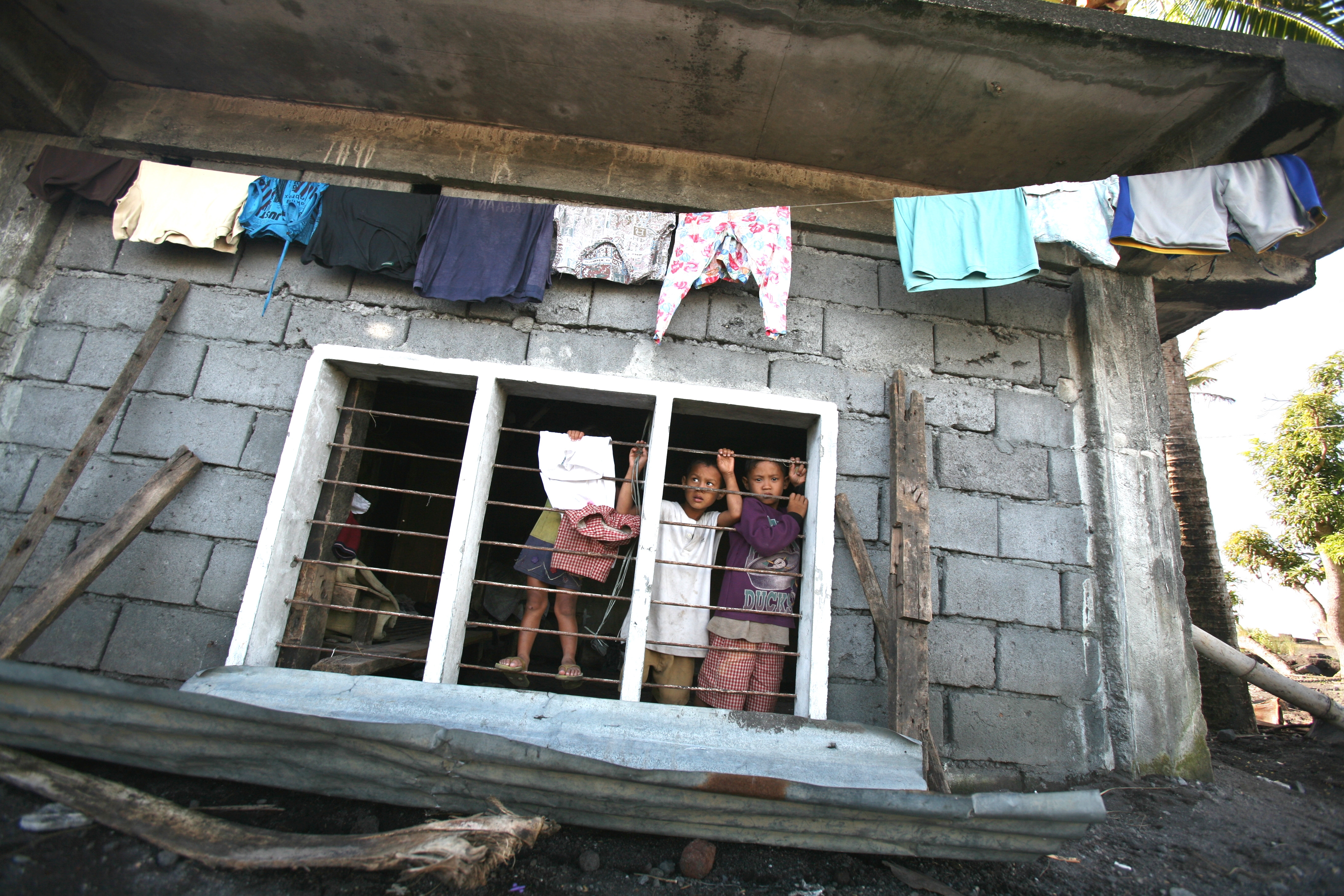 Children in a house damaged by typhoon, Maypon village in the Philippines