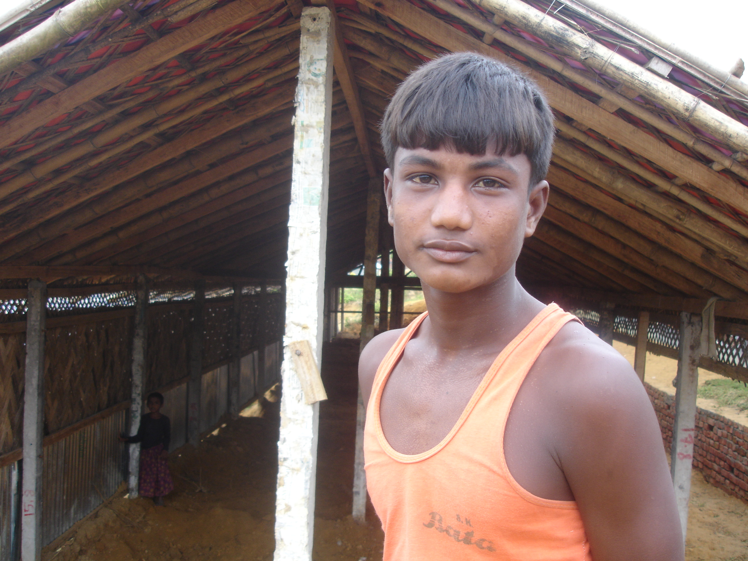 A young Rohingya man at the Kutupalong stands before one of a number of shelters now being replaced at the government-run camp.