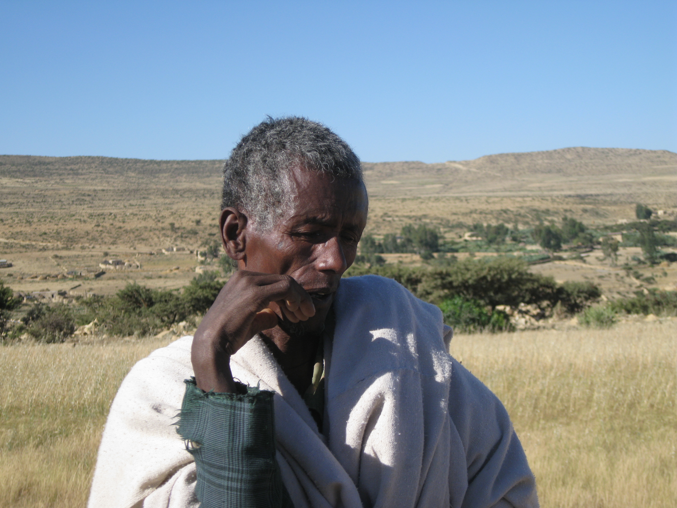 A farmer, Gebremedhin Gebregergis, stands next to his stunted Teff crop (a local millet) in the Kihen, Kilte Awlaelo woreda in Tigray region. He said he would let his livestock eat the crop as it had failed to produce adequate grain