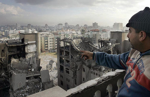 A Palestinian man looks out towards destroyed Hamas government buildings following an Israeli air strike in Gaza City on 30 December 2008. Earlier in the day, Israeli aircraft dropped at least 16 bombs on five Hamas government buildings in a Gaza City com