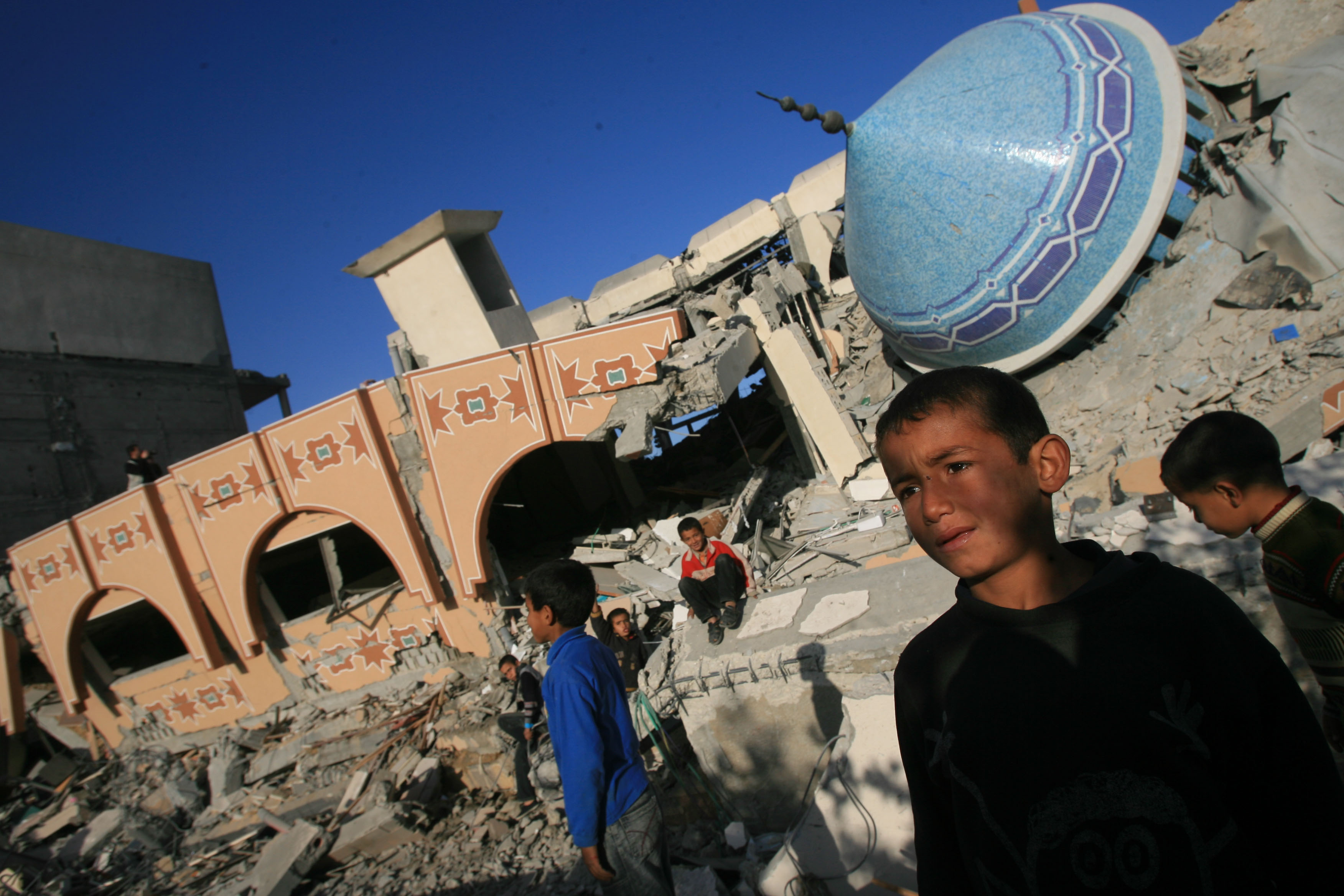 Palestinians inspect the rubble of a mosque and Islamic school after it was destroyed in an Israeli missile strike in Rafah, southern Gaza Strip