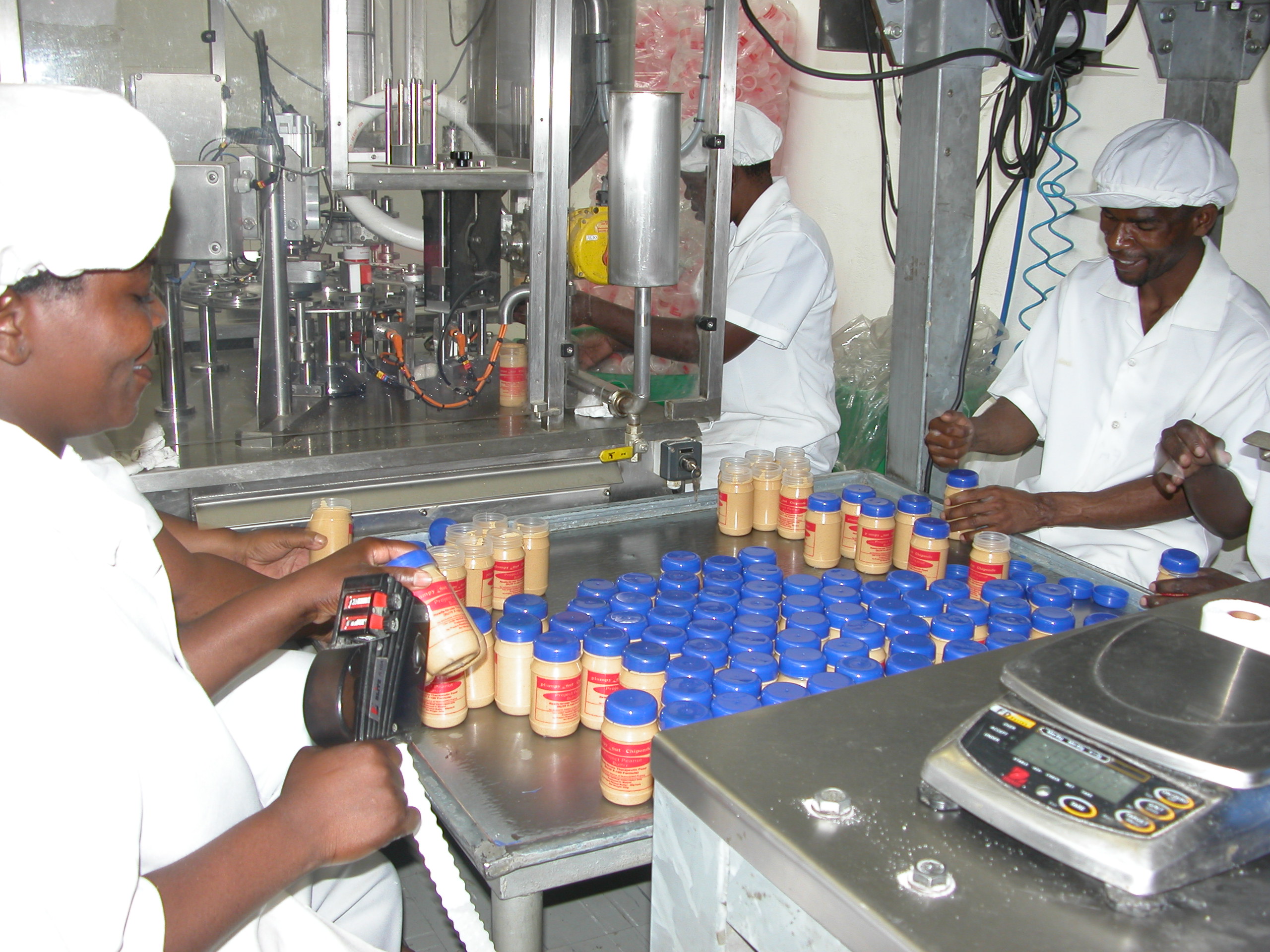 Workers at the Project Peanut Butter factory label containers of Plumpy'nut Chiponde