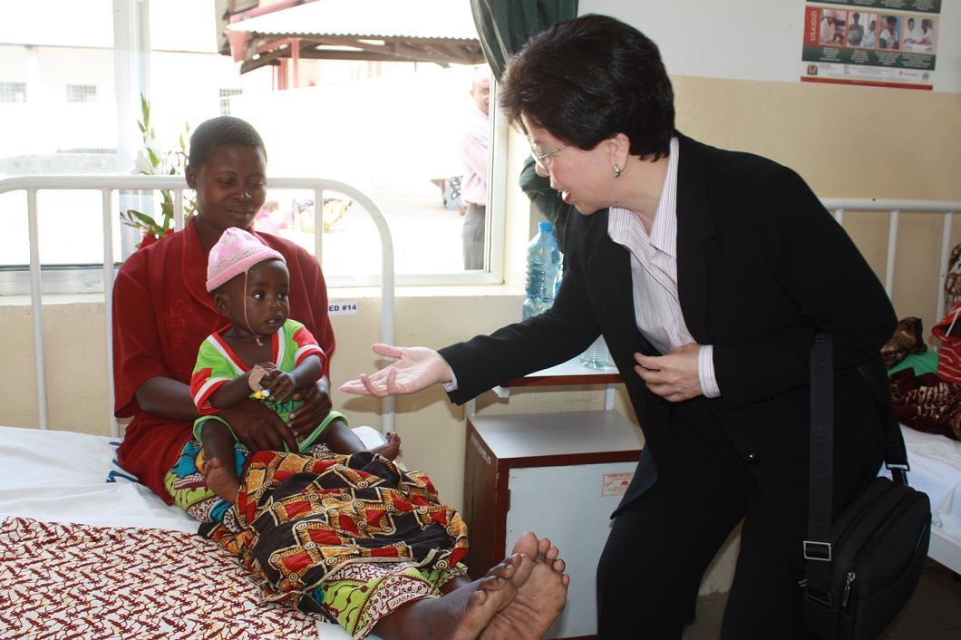 WHO Director General Margaret Chan greets a mother and child at a health centre in Bagamoyo town near Dar es Salaam, Tanzania on August 18, 2009. Chan was in Tanzania to highlight the country's success in fighting malaria