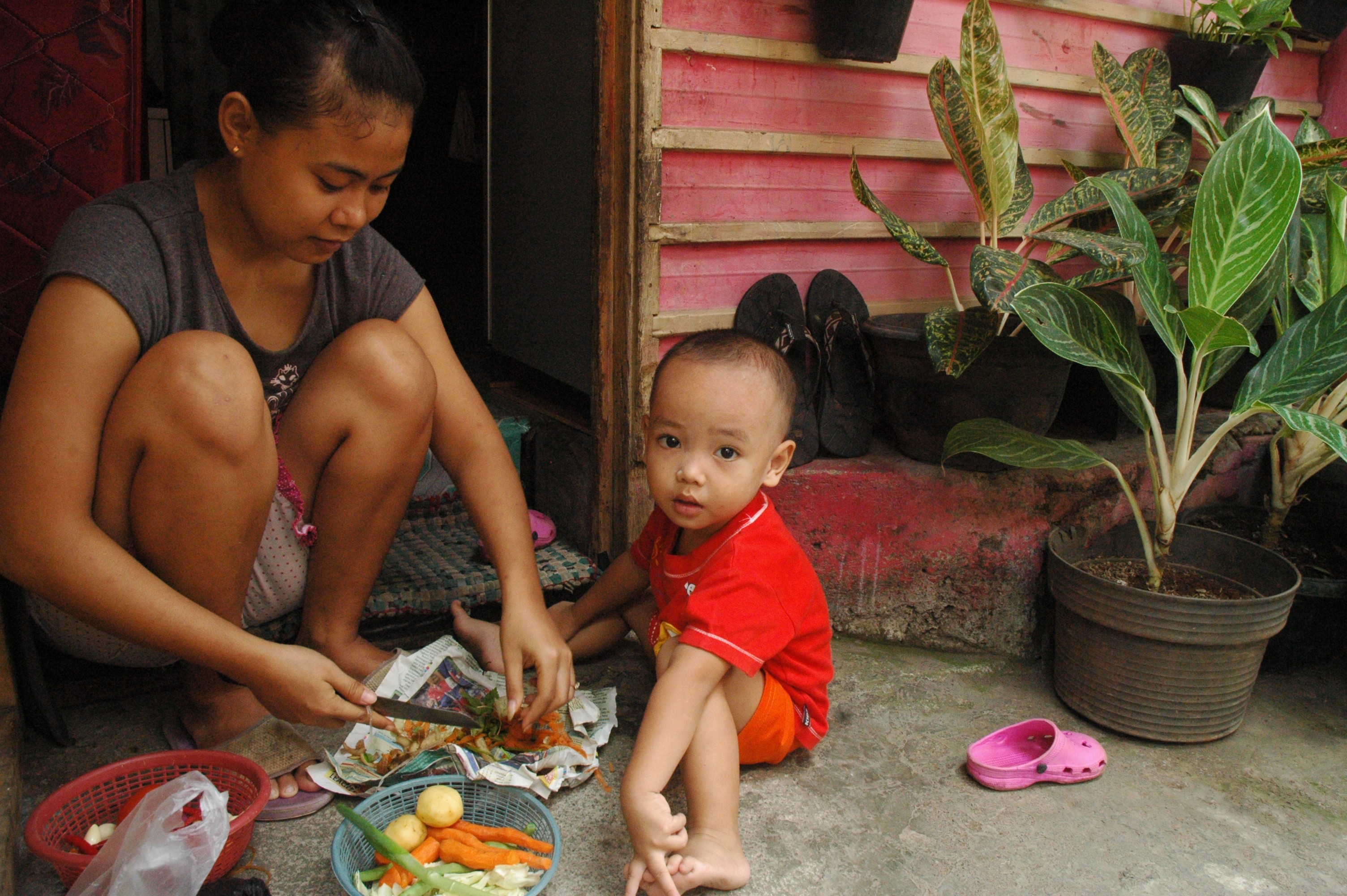 A young mother and her child outside their home near Jakarta. Thousands of children are unregistered in the country.