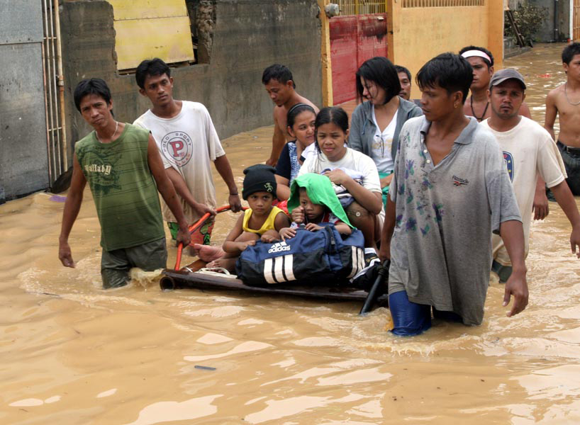 Residents use a makeshift raft to relocate children in this flooded section of Manila. Two weeks after unprecedented flooding in Manila and surrounding areas, the country has again plunged into crisis after continued rains by tropical storm Parma caused f