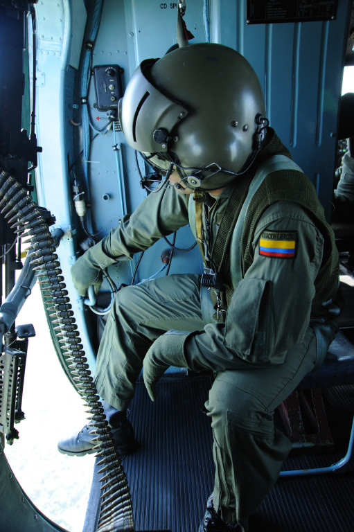 A helicopter door gunner in the Colombian army surveys the ground below