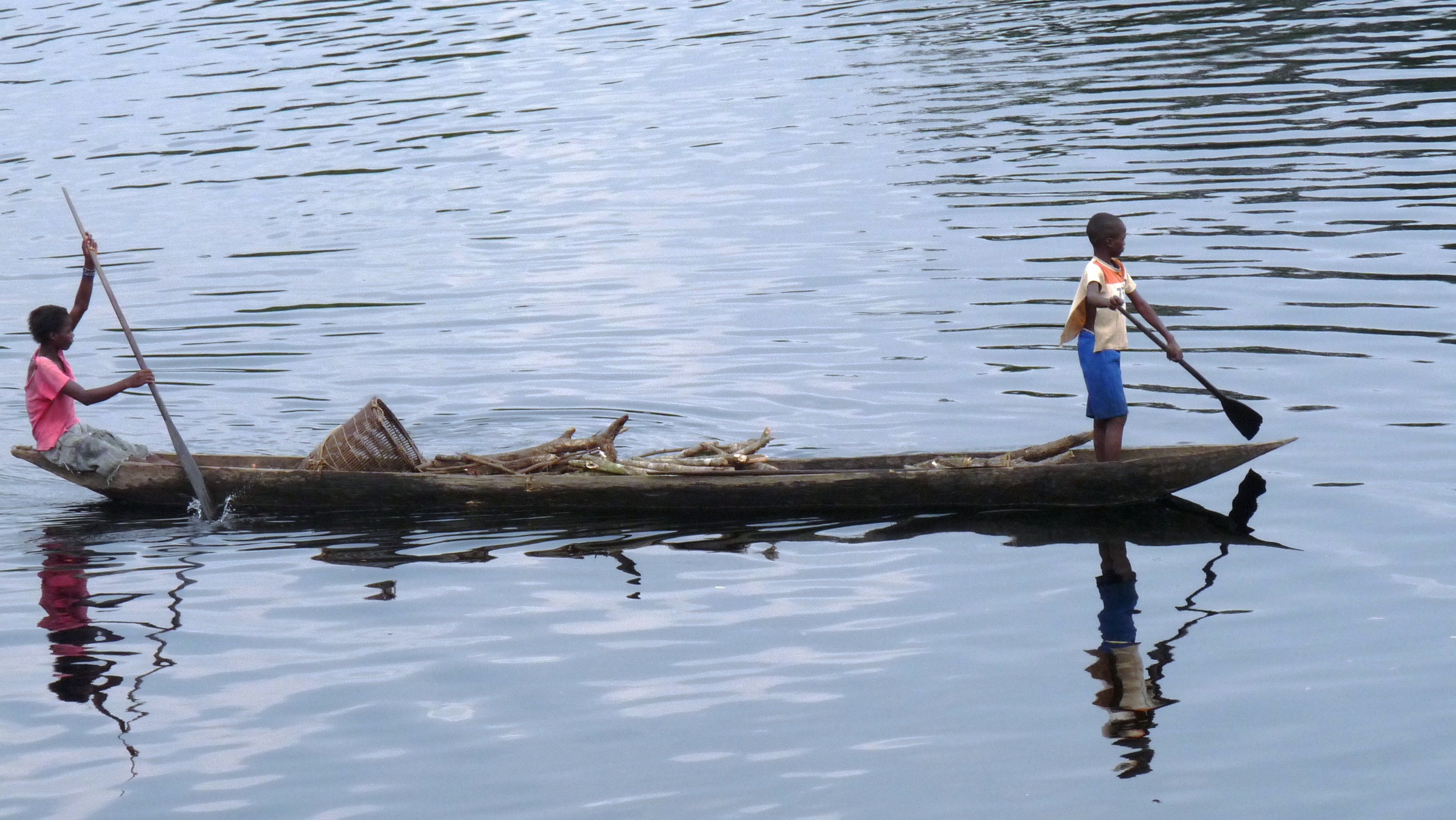 Two boys, refugees from clashes in Democratic Republic of Congo's Equateur Province, gather firewood on the Ugangi river, which marks the border between DRC and the Republic of Congo