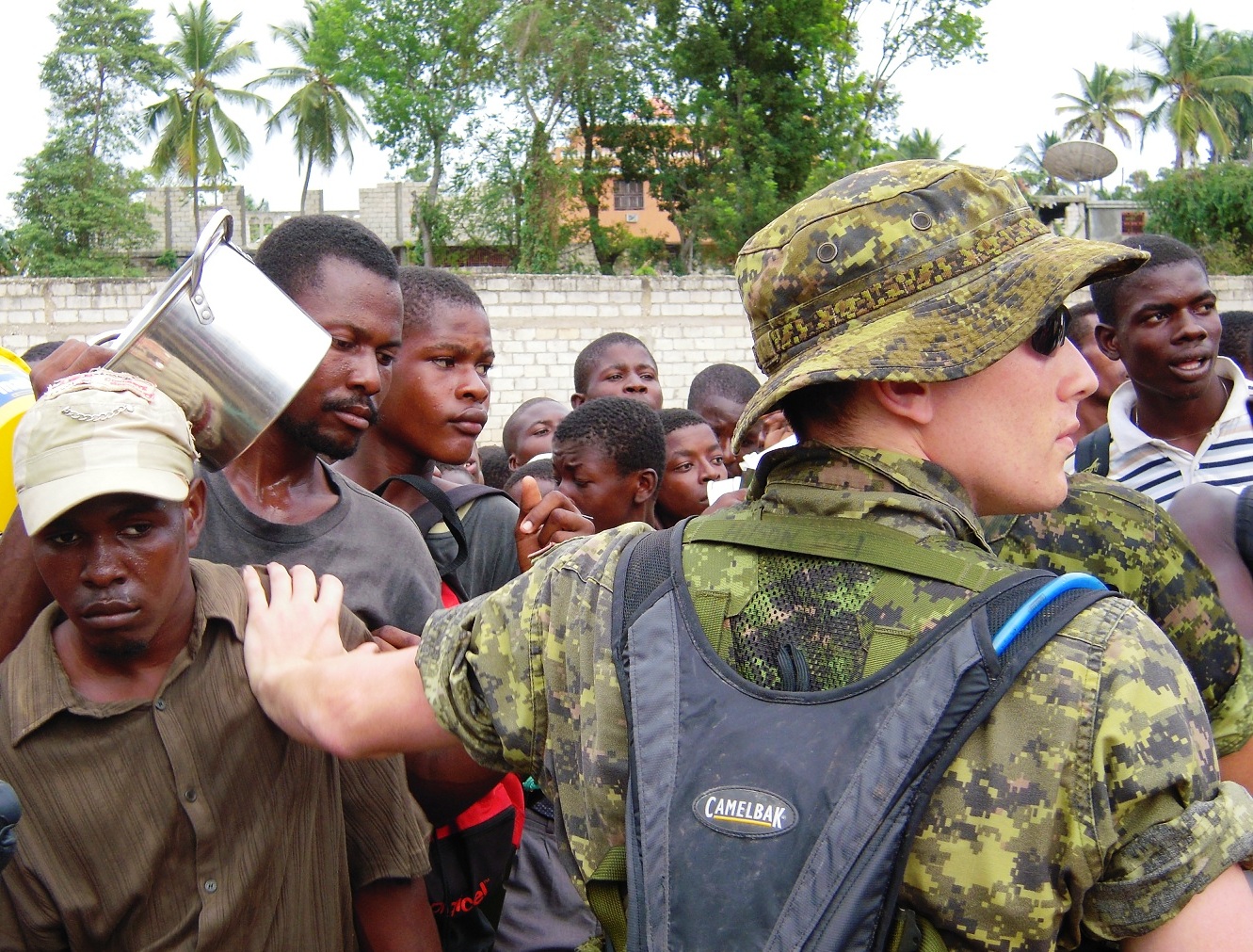 Canadian army holds back a rowdy crowd at the stadium in Jacmel