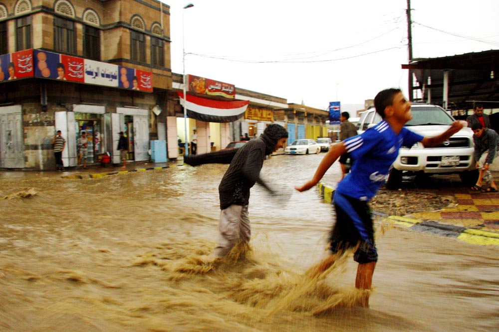 Children play in the flooded streets of Sana'a, the Yemeni capital, while the government fails to harvest the precious rainwater