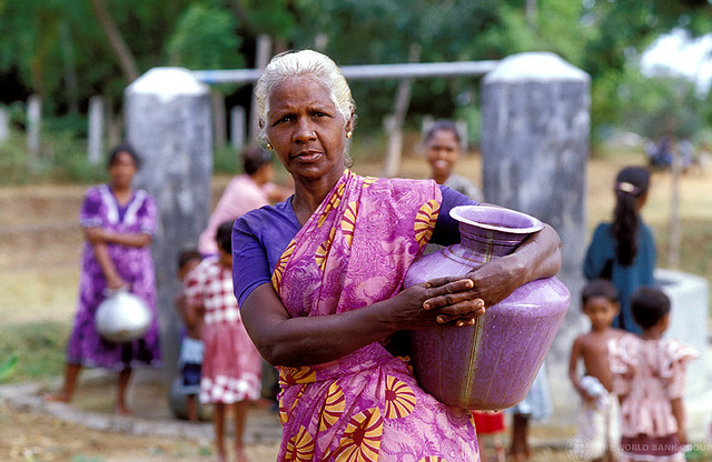 Woman with water container at well. Sri Lanka. For generic use
