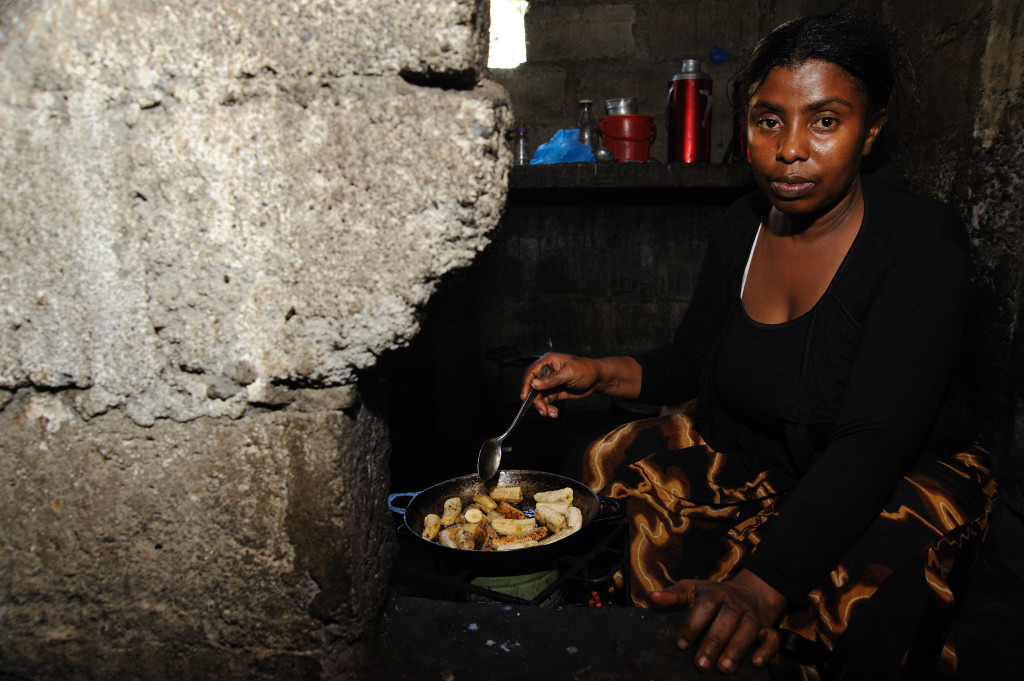 Fatima Maurice, 29, a former member of the Anjouan police, who was dismissed after being part of a rebellion against the government of Comoros, cooking food for her family in a room shared with her four children