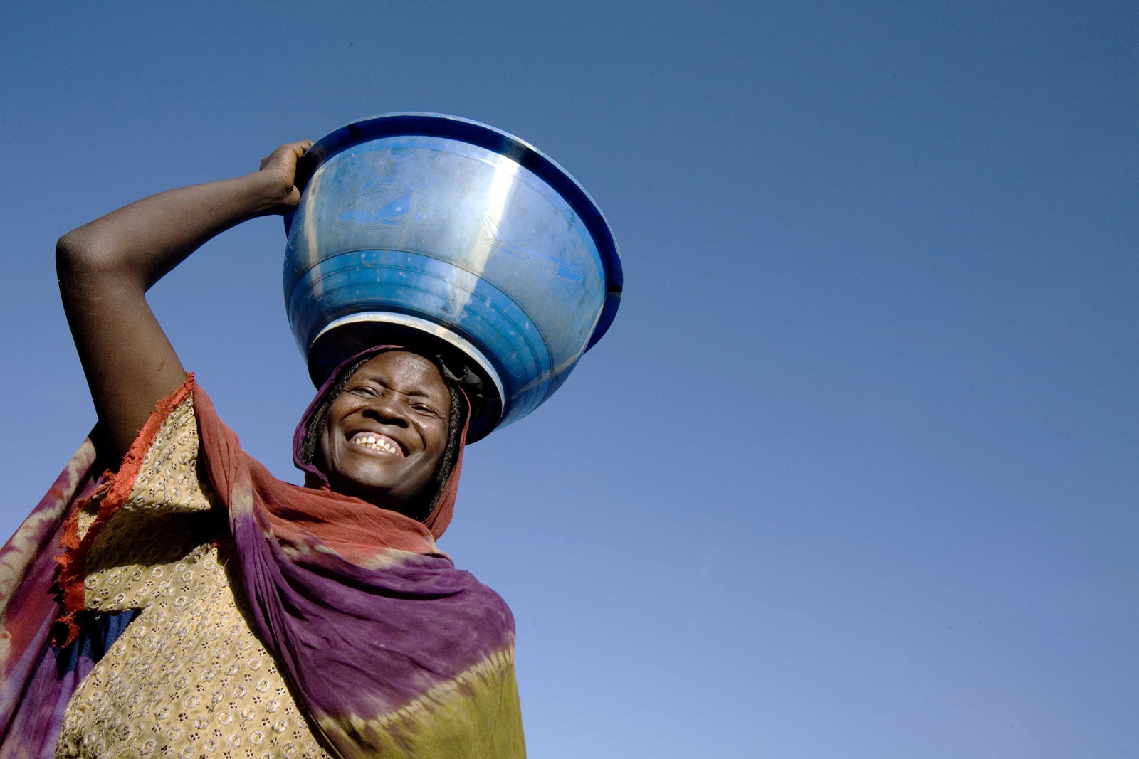 A woman carries water on her head at a settlement for displaced people in Goz Baeda, Eastern Chad