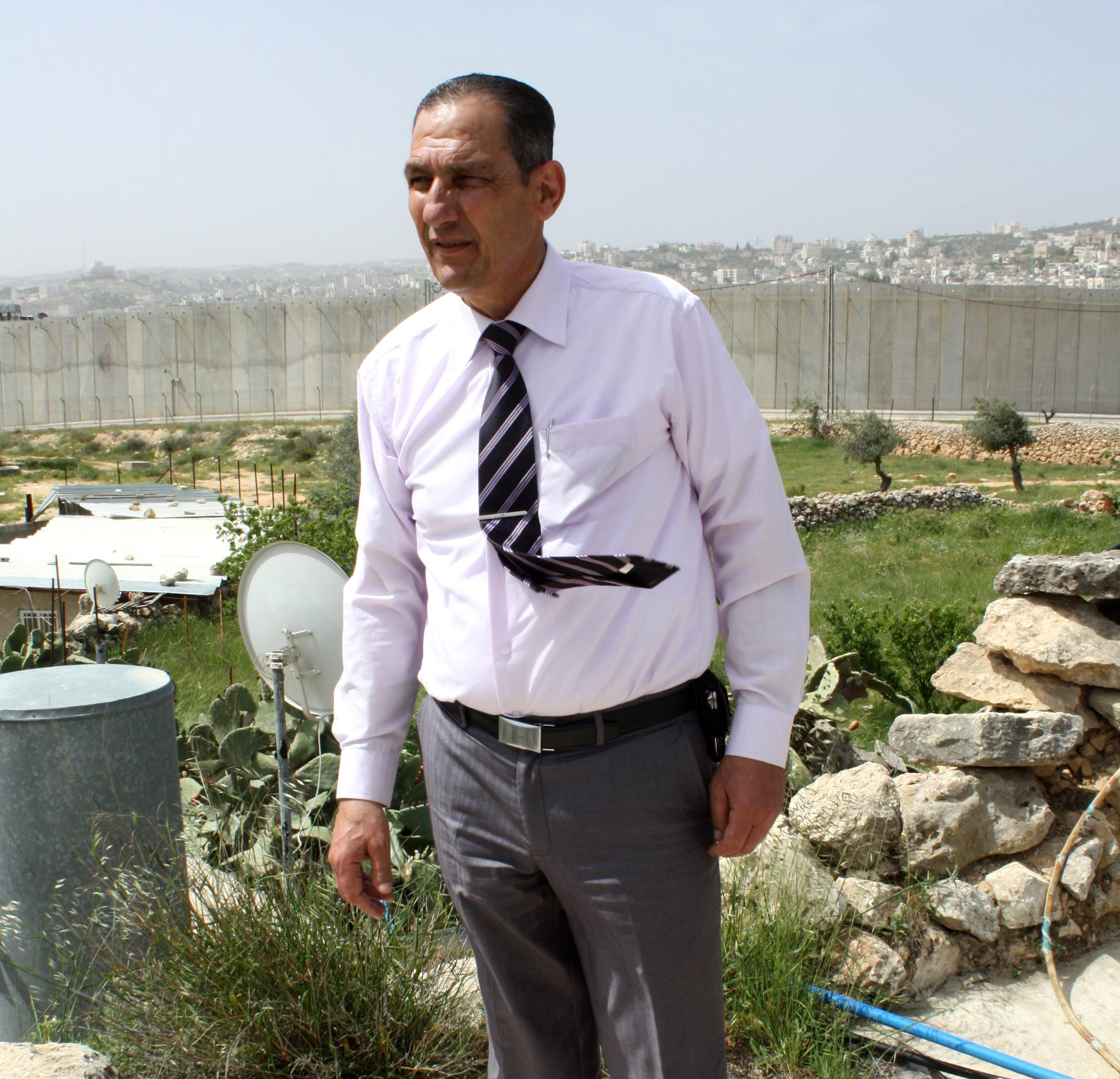 Fuad Ahmed Jado stands in front of his house in Tantour, East Jerusalem, where 80 residents have been cut off from hospitals in the West Bank by the Separation Wall