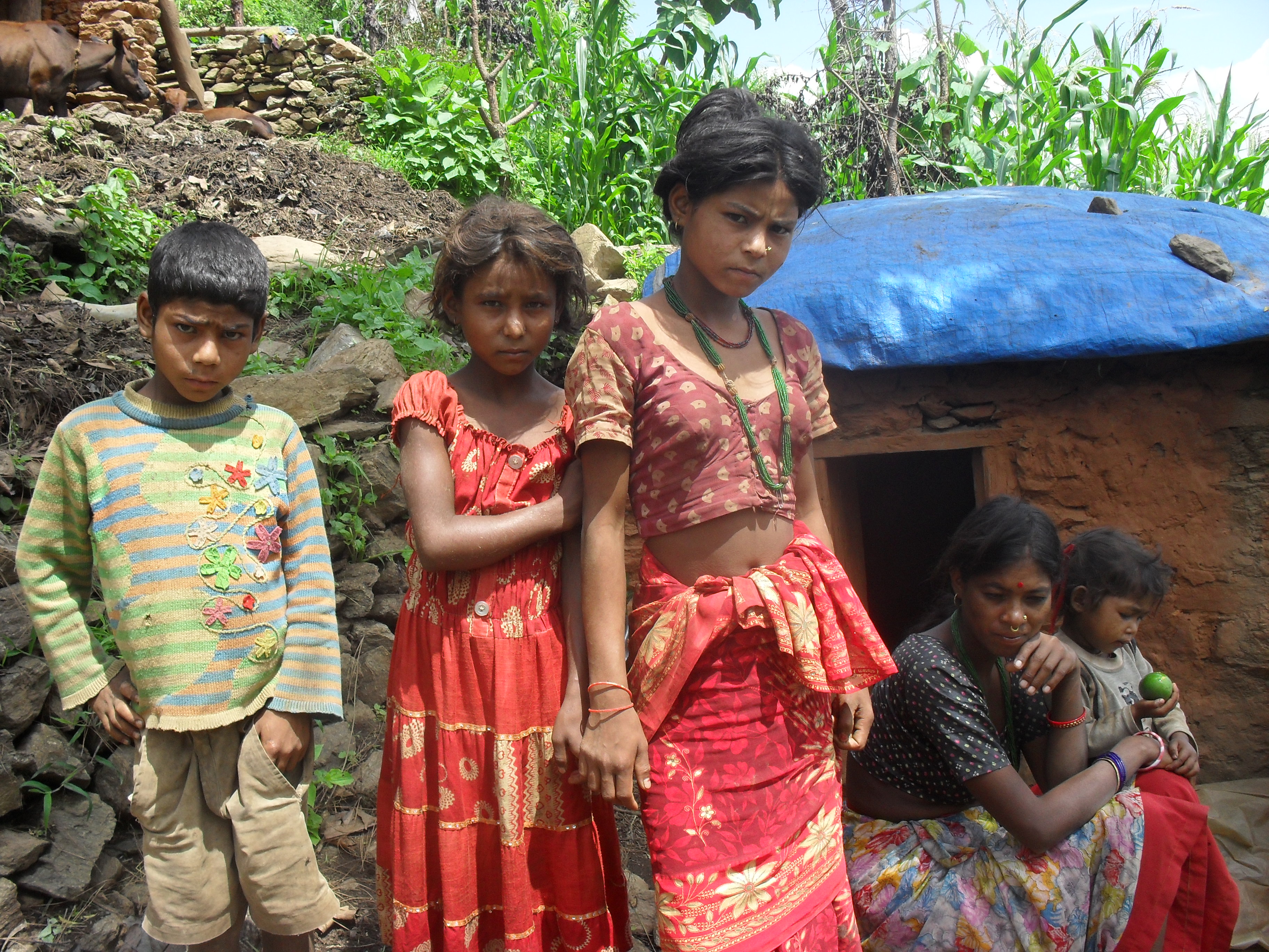 A group of Nepalese girls stand before a communal 'goth' in Nepal. Traditionally, a chhaupadi shed or hut is used to isolate menstruating women from the community