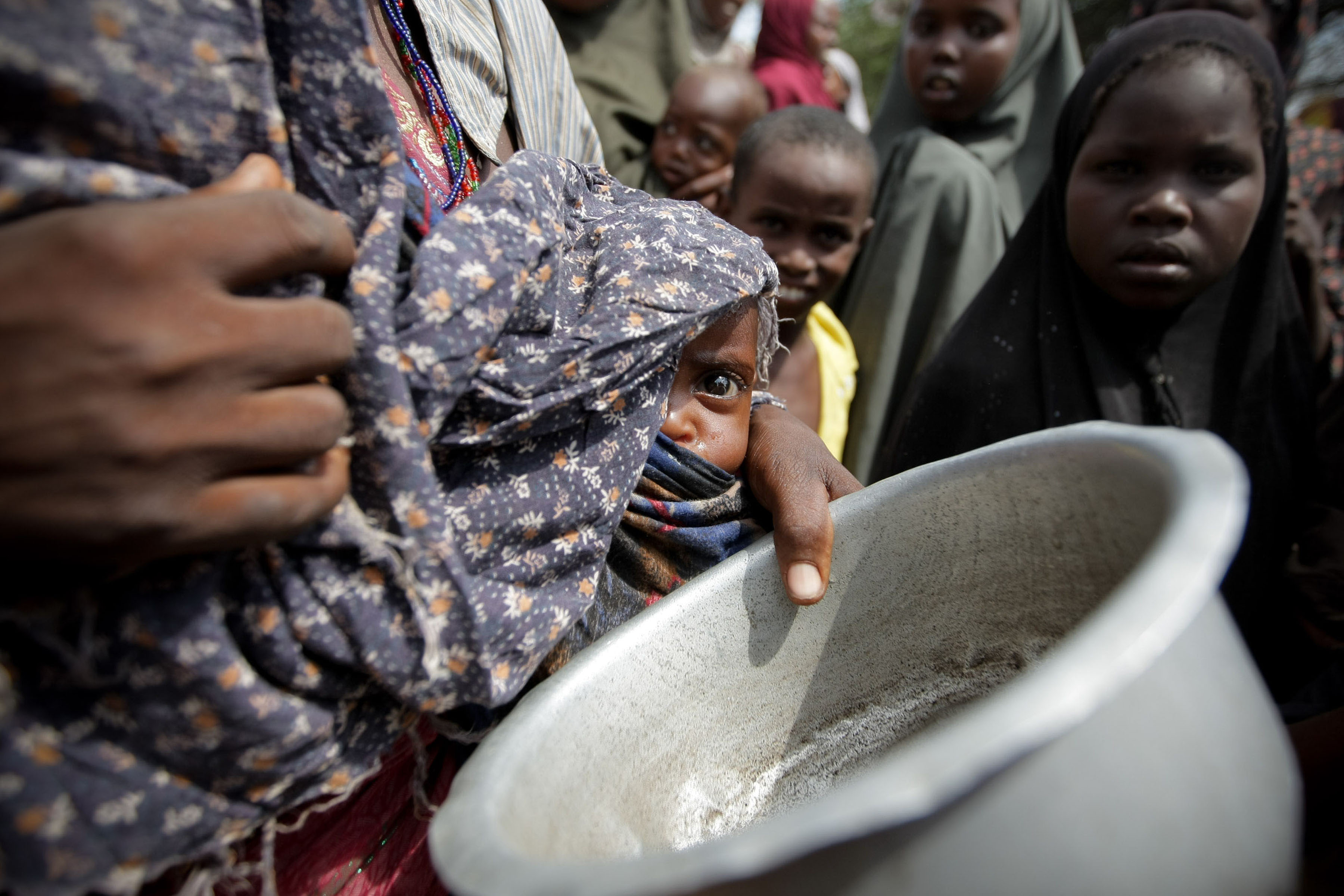A woman holding her young malnourished baby queues for food at the Badbado camp for Internally Displaced Persons (IPDs)