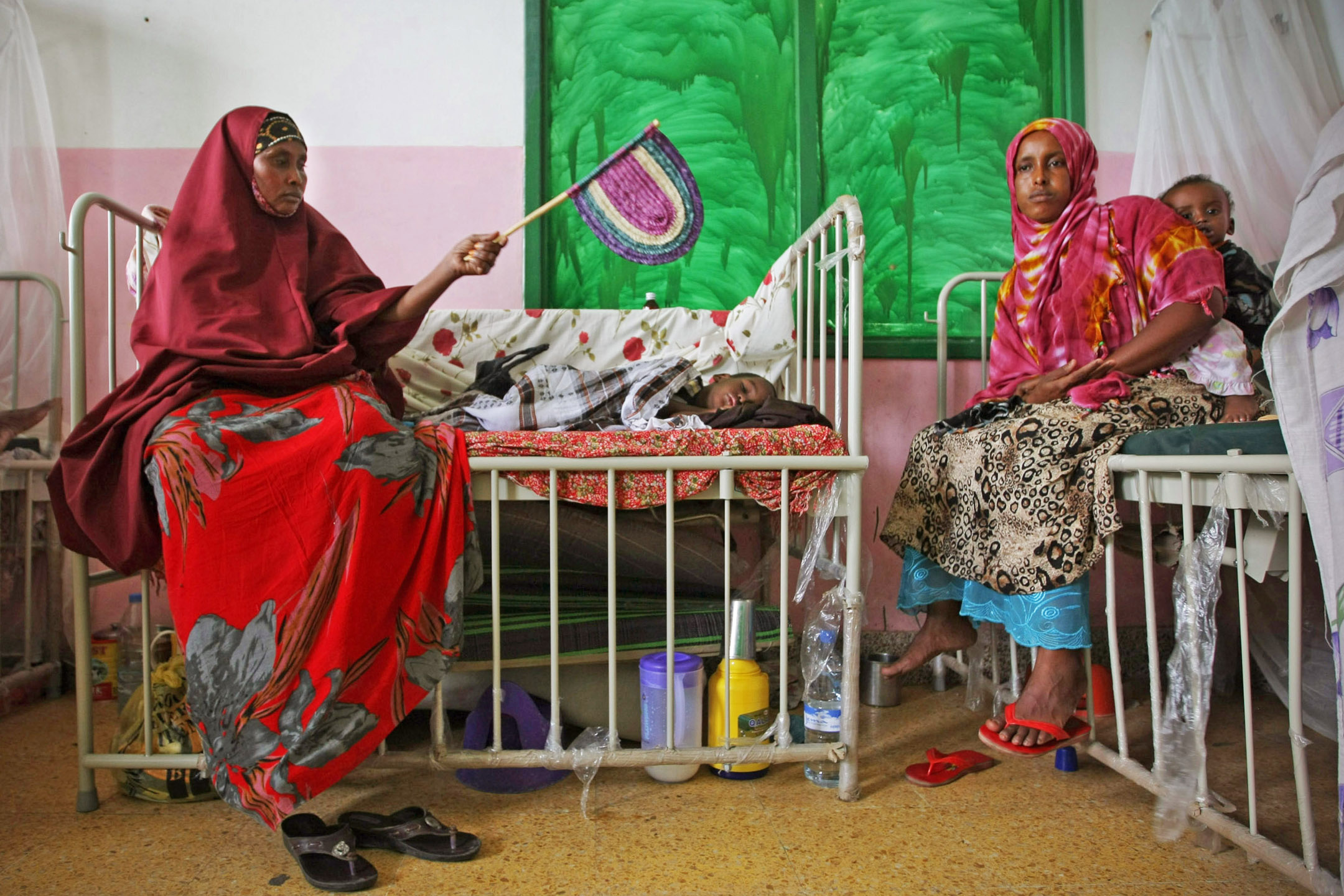 Mothers sit with their malnourished and dehydrated children in a ward at Banadir Hospital in the Somali capital Mogadishu