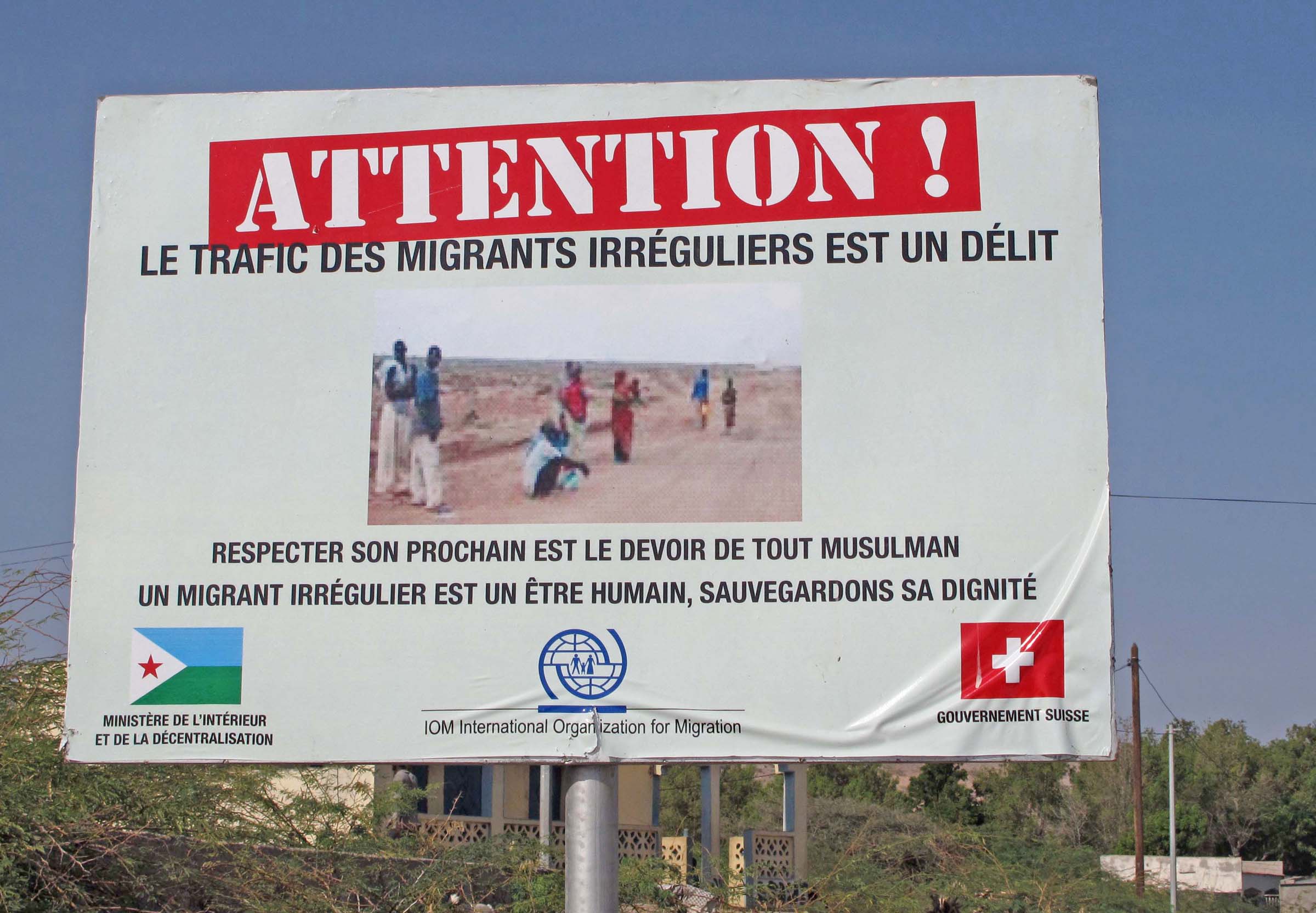 A sign on the road to Obock erected by the International Organization for Migration (IOM) reads: Attention! Trafficking migrants is an offense! Respecting your neighbour is the responsibility of every Muslim. Migrants are human beings – protect their di