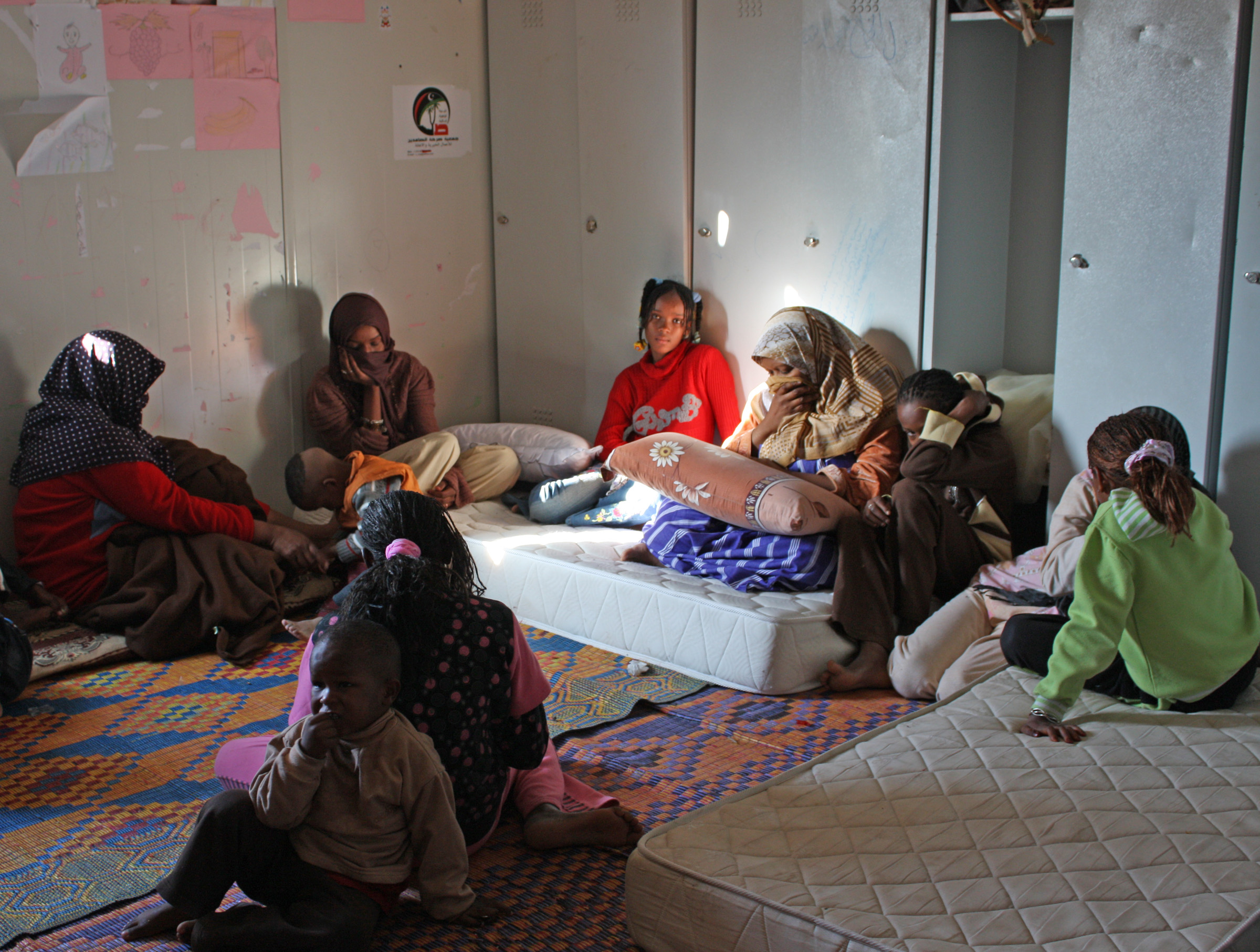 Displaced women and children from the Libyan town of Tawergha weep over dead or detained relatives at a site for displaced people in Tripoli. (Airport Road / Turkish Compound site, November 2011)
