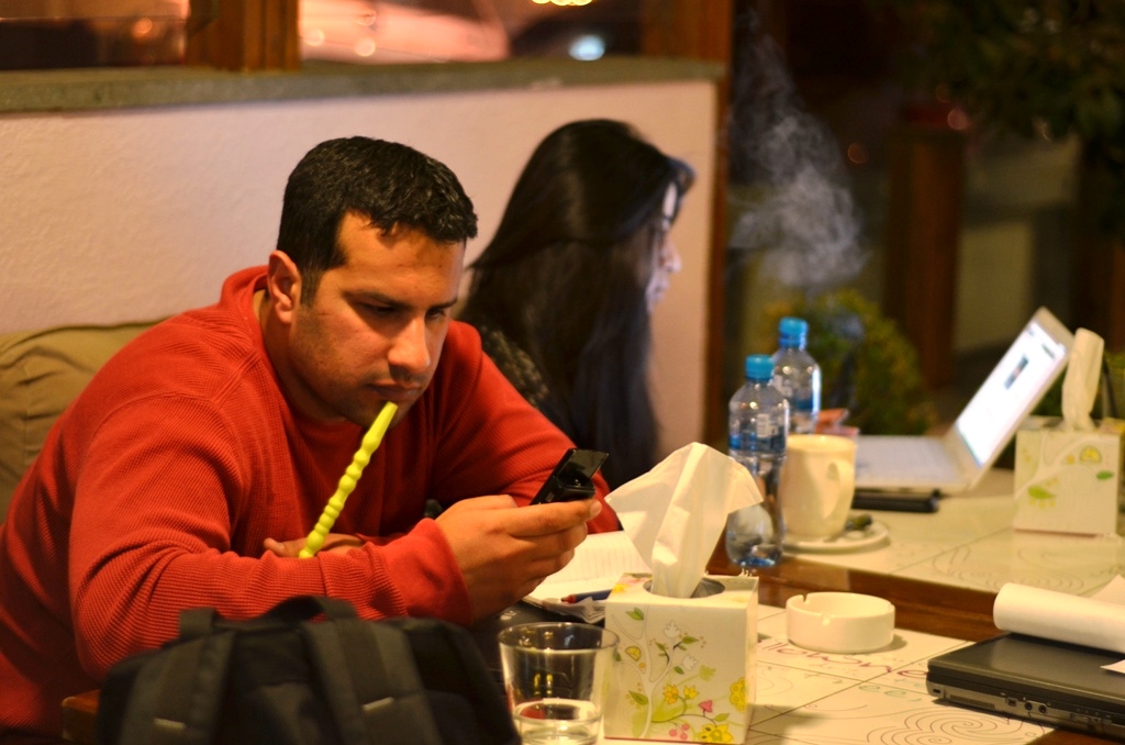 Ahmed Almasri, a Syrian refugee/activist in Jordan, sits in a trendy coffeeshop in Amman, where he organizes the illegal smuggling of medical and communications equipment into Syria