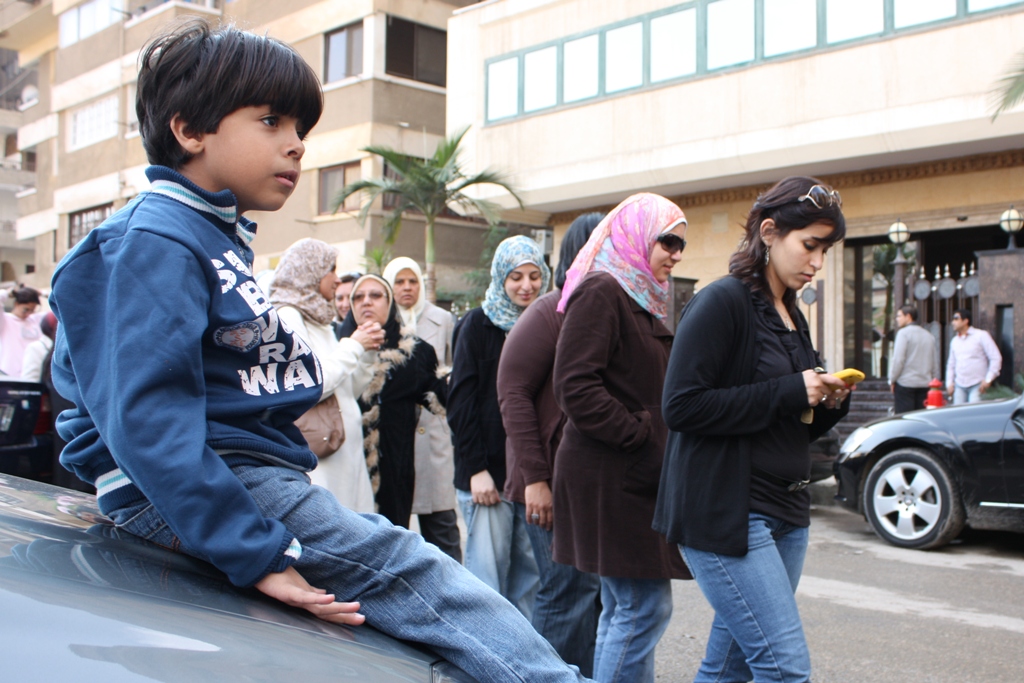 A young Egyptian boy waits while his mother stands in line to vote during the first free and fair parliamentary elections in Egypt in November 2011